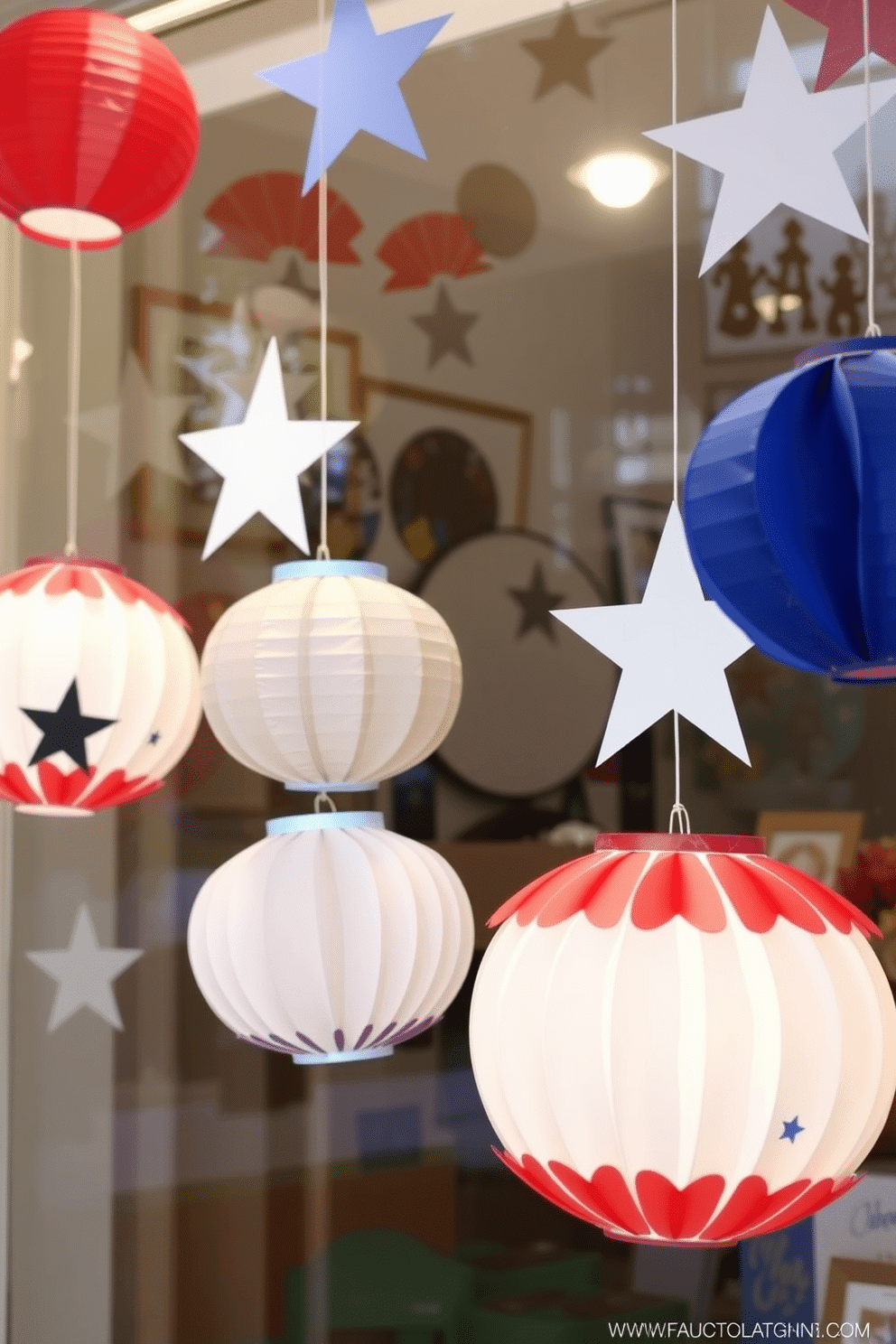 Create a festive window display featuring DIY paper lanterns adorned with stars. The lanterns are crafted from red white and blue paper and are hung at varying heights to create a dynamic look.