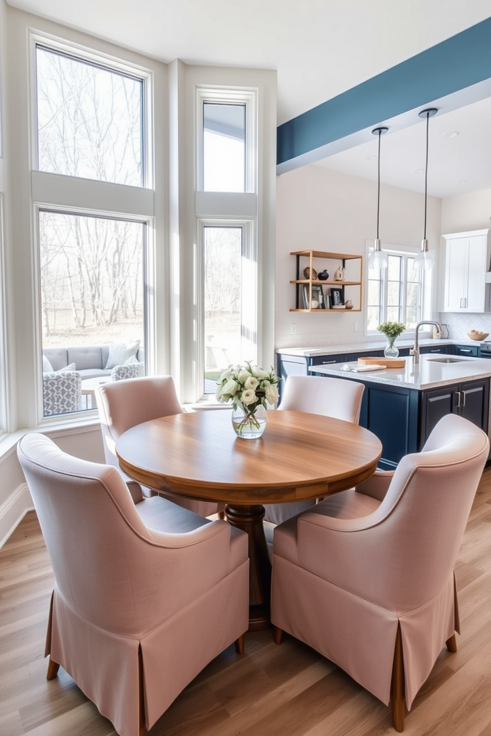 A cozy breakfast nook is nestled by large windows, featuring a round wooden table surrounded by plush, upholstered chairs in soft pastel hues. Sunlight streams in, illuminating the space and highlighting the delicate floral centerpiece on the table. The kitchen seamlessly flows into the family room, showcasing an open layout that encourages family interaction. Modern cabinetry in a rich navy blue contrasts beautifully with the light-colored quartz countertops, while a stylish island provides additional seating and prep space.