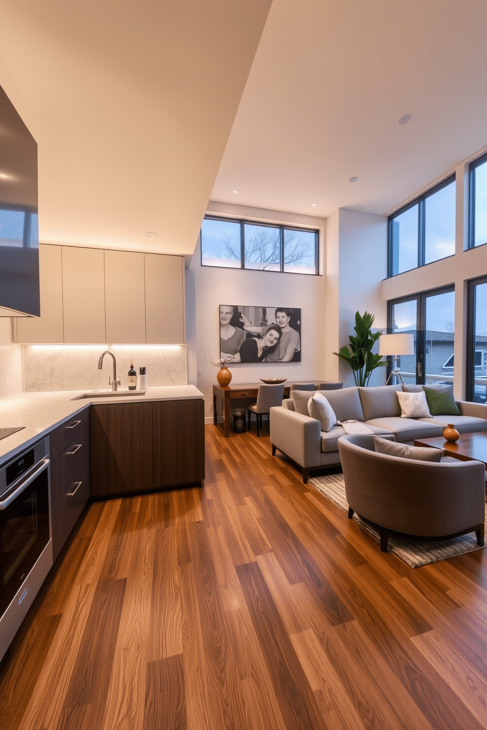 A modern kitchen family room combo featuring an open layout that seamlessly integrates cooking and relaxation spaces. The kitchen boasts sleek cabinetry with under-cabinet lighting accents that illuminate the marble countertops, creating a warm and inviting atmosphere. Adjacent to the kitchen, the family room showcases a cozy seating arrangement with a plush sectional sofa and a stylish coffee table. Large windows allow natural light to flood the space, highlighting the rich wood flooring and contemporary decor elements throughout the room.