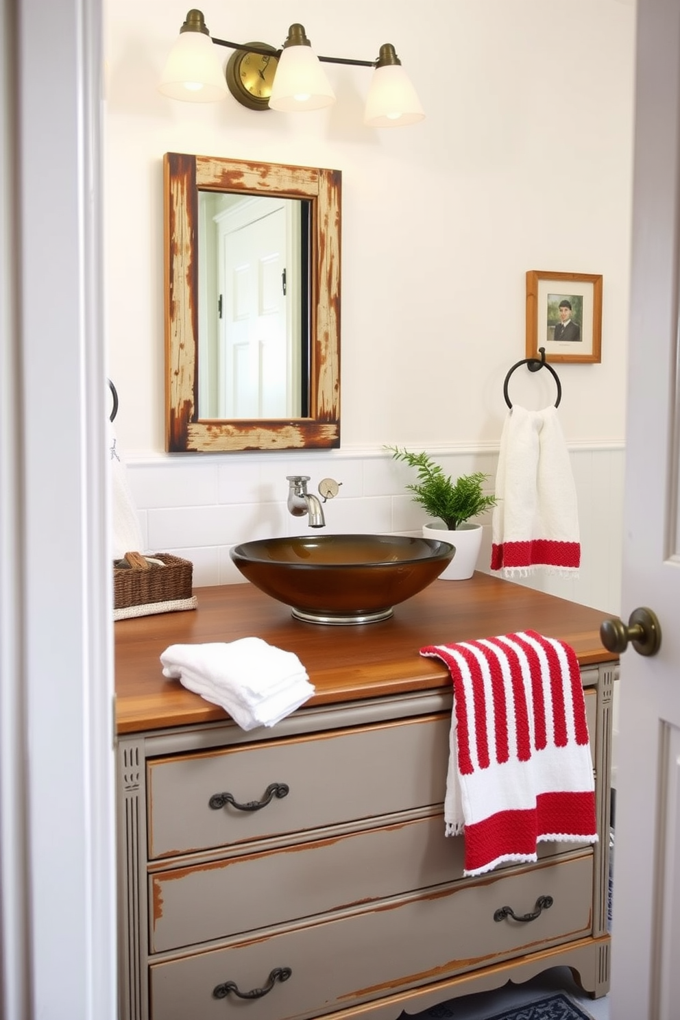 A cozy bathroom featuring repurposed furniture adds unique charm to the space. A vintage dresser serves as a stylish vanity with a vessel sink on top, complemented by a rustic mirror hanging above. To celebrate Labor Day, the bathroom is adorned with subtle patriotic accents. Soft red, white, and blue towels are neatly arranged, and a small potted plant adds a touch of freshness to the decor.