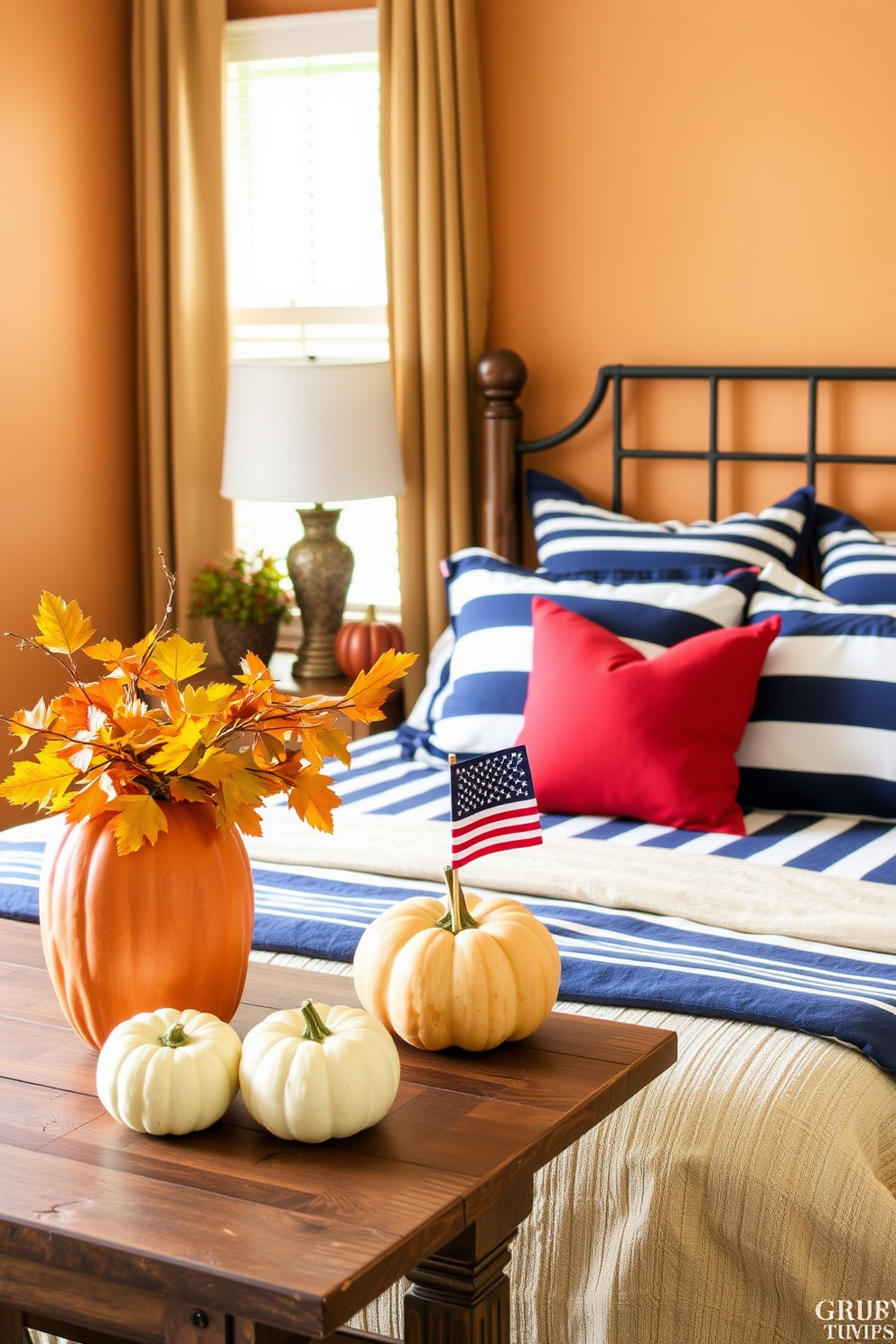 Seasonal decor for a festive touch. The room features a warm color palette with autumn leaves and pumpkins arranged on a rustic wooden table. Labor Day Bedroom Decorating Ideas. The space showcases a cozy bed adorned with navy blue and white striped linens, complemented by red accent pillows and a small American flag decoration.