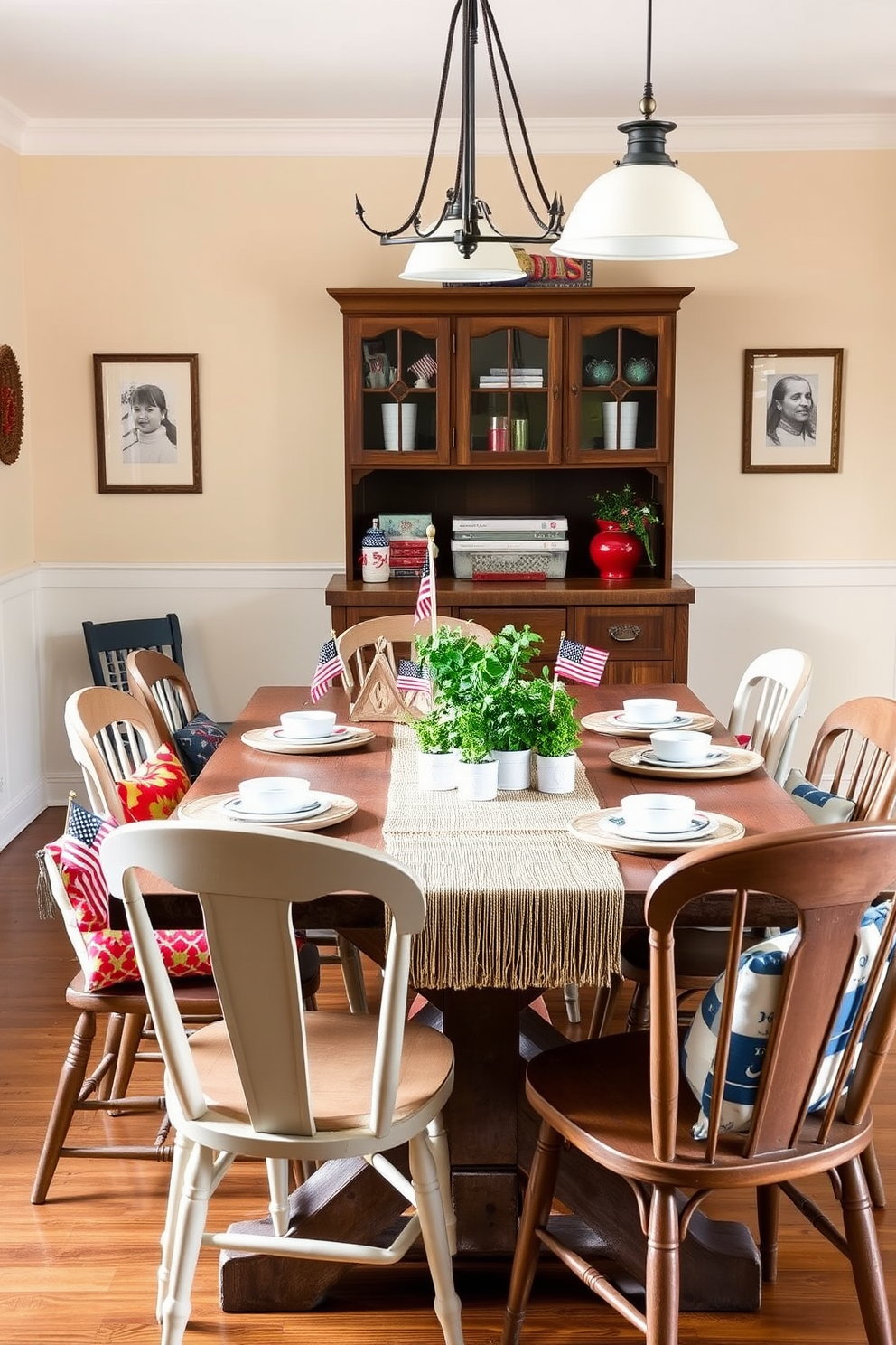 A charming dining room featuring a rustic wooden table set for a festive Labor Day gathering. Surrounding the table are mismatched chairs, each adorned with colorful cushions, and a centerpiece of fresh herbs in small pots adding a lively touch. The walls are painted in a warm cream tone, complemented by soft, ambient lighting from stylish pendant lamps. A woven table runner adds texture, while seasonal decorations such as small American flags and red, white, and blue accents create a celebratory atmosphere.