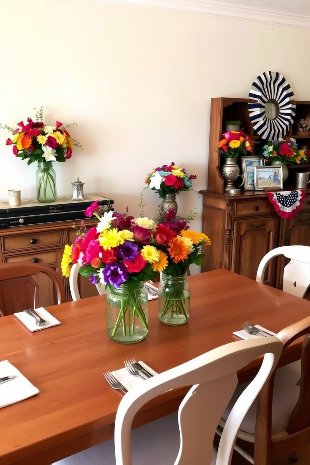 A vibrant dining room setting adorned with colorful floral arrangements in mason jars. The table is set with elegant dinnerware and surrounded by mismatched chairs that add a charming touch. The walls are painted in a soft cream, creating a warm and inviting atmosphere. A rustic wooden sideboard displays additional floral arrangements and seasonal decorations for Labor Day.