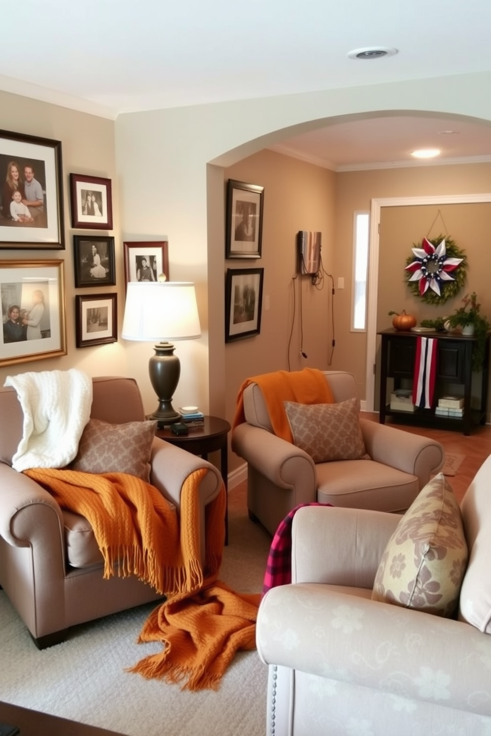 A cozy living room features seasonal throw blankets draped over plush armchairs. The blankets are in warm autumn colors, adding a touch of comfort and inviting relaxation. The hallway is adorned with tasteful decorations for Labor Day. Red, white, and blue accents are displayed alongside framed photographs and a festive wreath on the door.