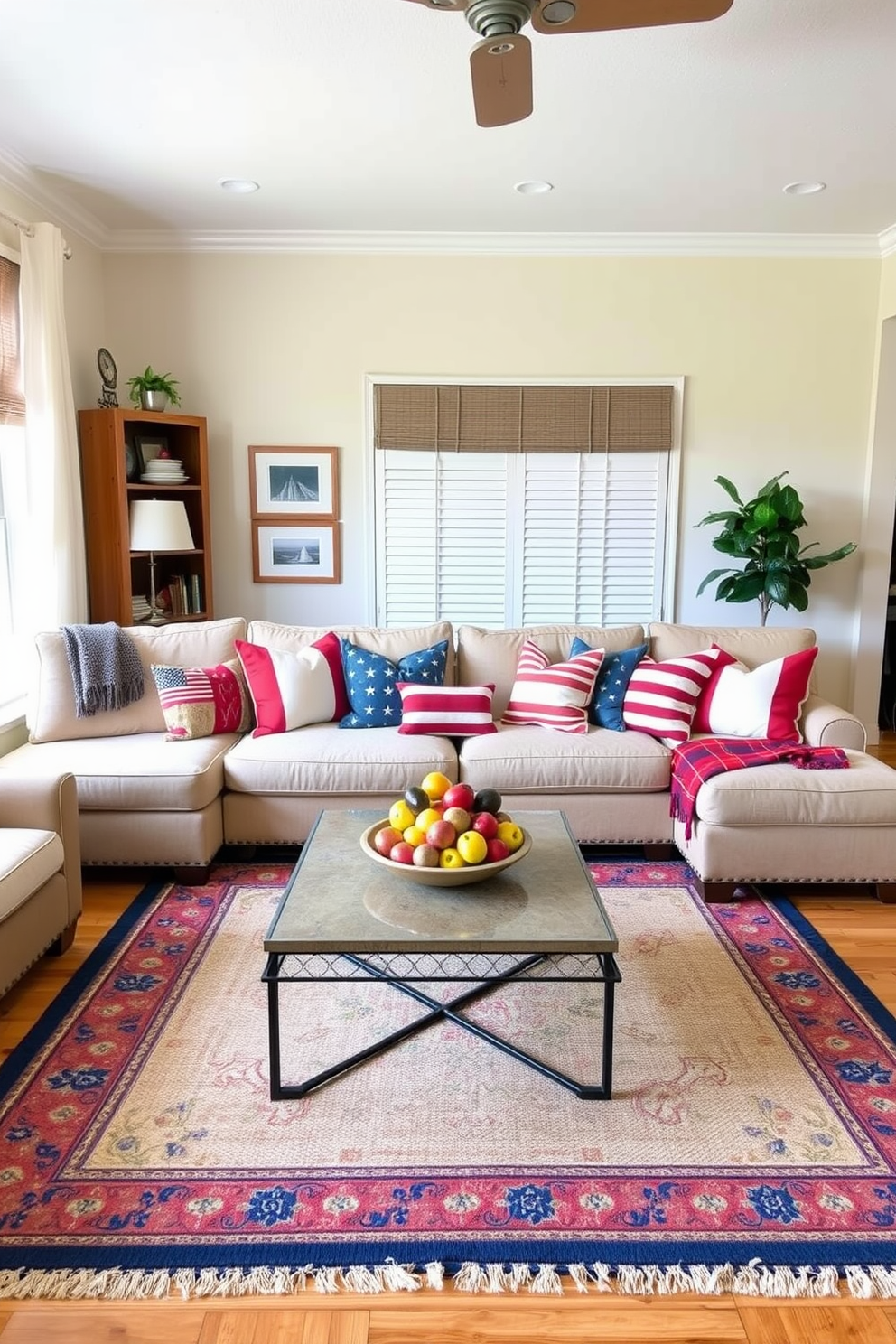 A cozy living room setting designed for Labor Day celebrations. There is a plush sectional sofa adorned with festive pillows in red, white, and blue hues, creating a welcoming atmosphere. The walls are painted in a soft cream color, complementing the warm wooden accents throughout the space. A large area rug anchors the seating area, while a coffee table in the center holds a decorative bowl filled with seasonal fruits.