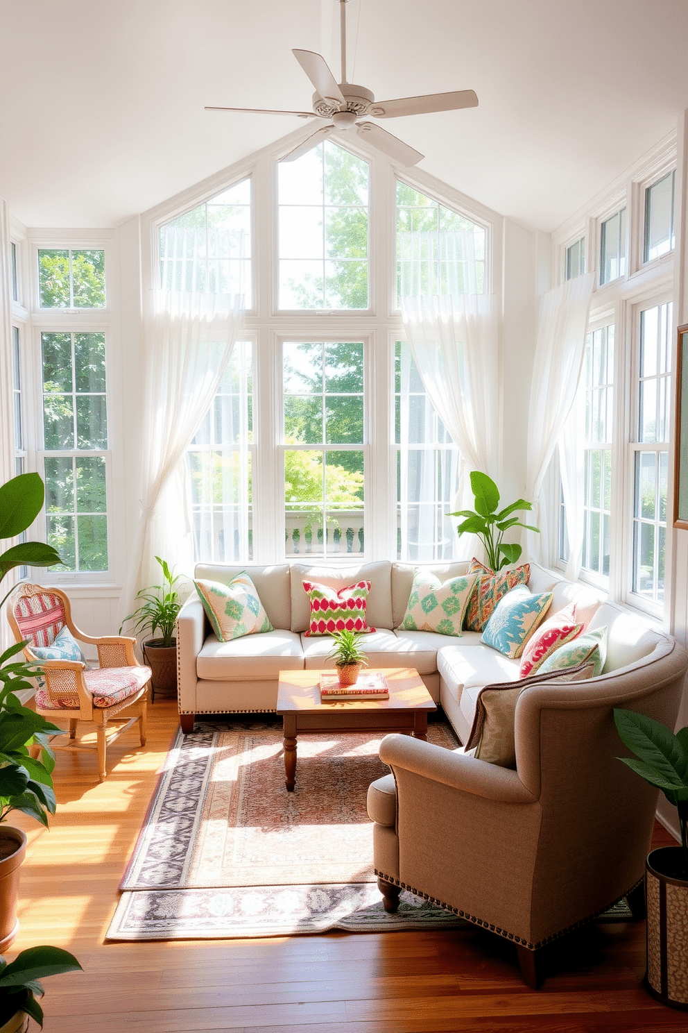 A bright and inviting sunroom filled with natural light. There are large windows adorned with sheer white curtains that gently diffuse the sunlight, creating a warm ambiance. In the center, a comfortable seating arrangement features a plush sectional sofa with colorful throw pillows. A patterned area rug anchors the space, adding texture and visual interest to the hardwood floor. A wooden coffee table sits in front of the sofa, topped with a few decorative books and a small potted plant. On one side, a cozy reading nook is created with a vintage armchair and a small side table, perfect for relaxation. Lush green plants are placed in various corners, bringing a touch of nature indoors. The walls are painted in a soft pastel hue, enhancing the cheerful and welcoming atmosphere of the sunroom.