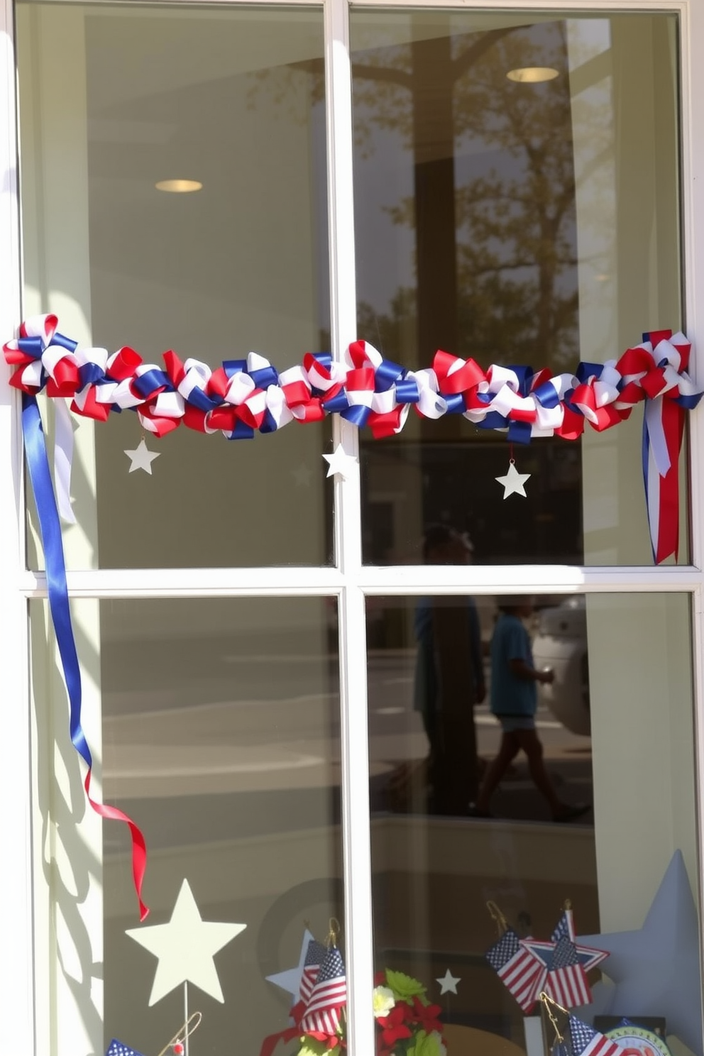 A festive window display featuring red white and blue ribbon garlands draped elegantly across the top. The garlands are complemented by small decorative stars and patriotic themed accents, creating a cheerful atmosphere for Labor Day.