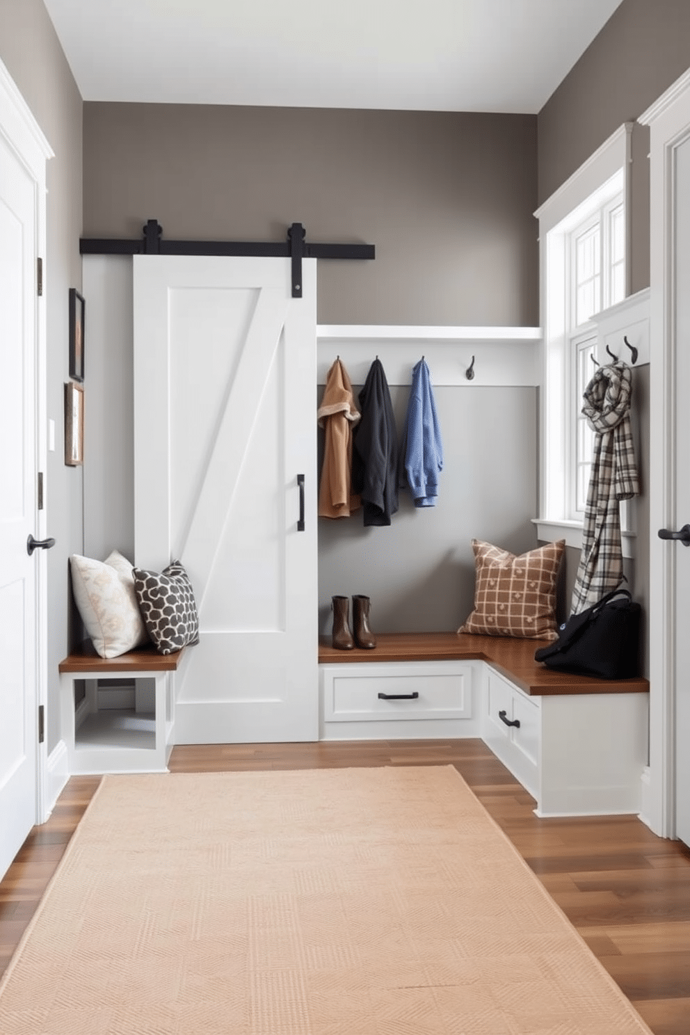 A modern mudroom featuring a sliding barn door for space-saving efficiency. The design includes built-in benches with storage underneath, hooks for coats, and a large rug in a neutral color to complement the space.