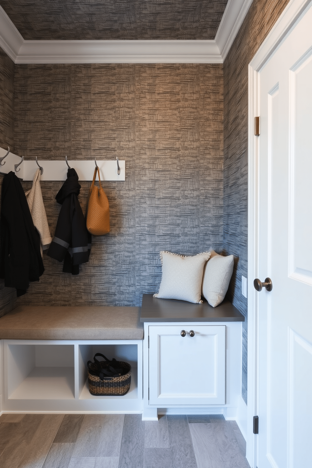 A spacious mudroom features textured wallpaper that adds depth and character to the space, enhancing its overall aesthetic. The room includes built-in storage benches with plush cushions, alongside hooks for hanging coats and bags, creating a functional yet stylish entryway.