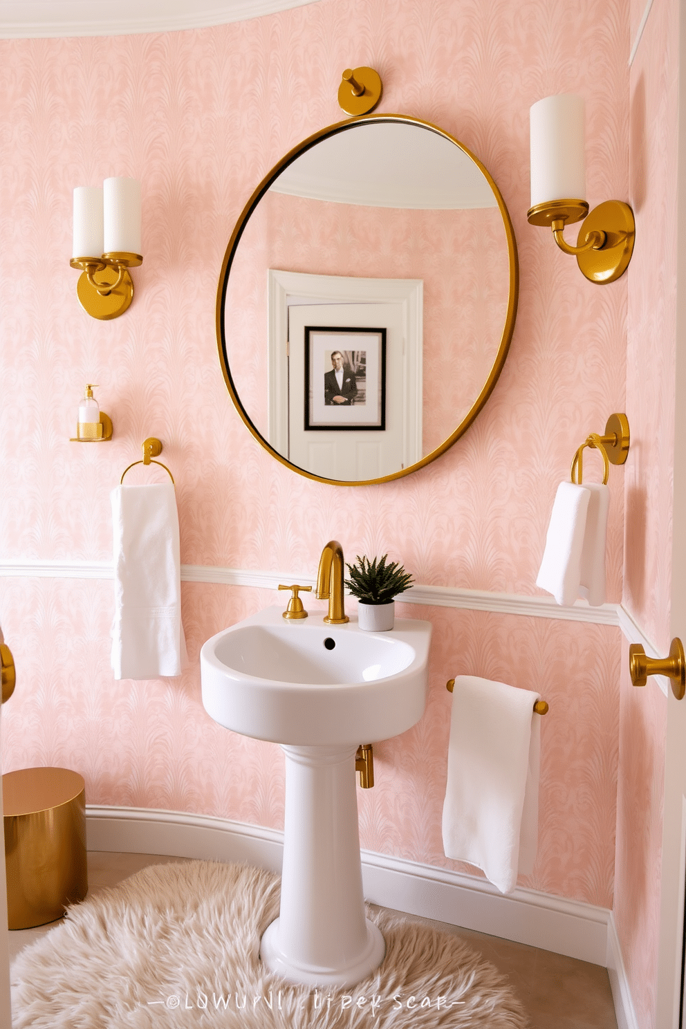 A chic powder room featuring elegant gold fixtures and accessories. The walls are adorned with a soft blush wallpaper, complemented by a large round mirror with a gold frame above a sleek white pedestal sink. The space includes a stylish gold faucet and matching towel bars, enhancing the luxurious feel. A plush, patterned area rug lies beneath the sink, while a small potted plant adds a touch of greenery to the decor.