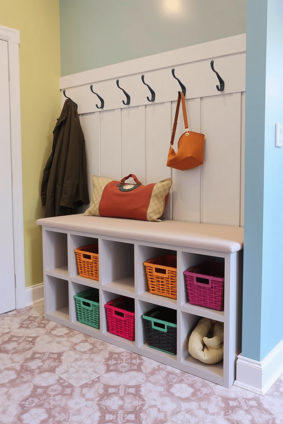 Cozy bench with storage underneath. The bench is upholstered in a soft, neutral fabric, and features built-in cubbies filled with colorful baskets for organization. Laundry mudroom design ideas. The space includes a stylish, tiled floor with a durable finish, and wall-mounted hooks for hanging coats and bags, complemented by a cheerful color palette.