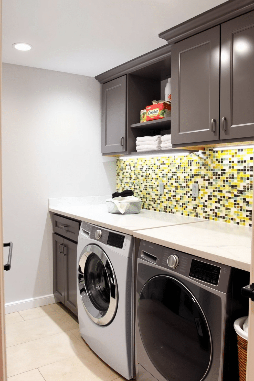 A laundry room in a basement featuring a vibrant mosaic backsplash that adds a pop of color to the space. The room includes a spacious countertop for folding clothes, with built-in cabinetry for storage and a stylish washer and dryer set.