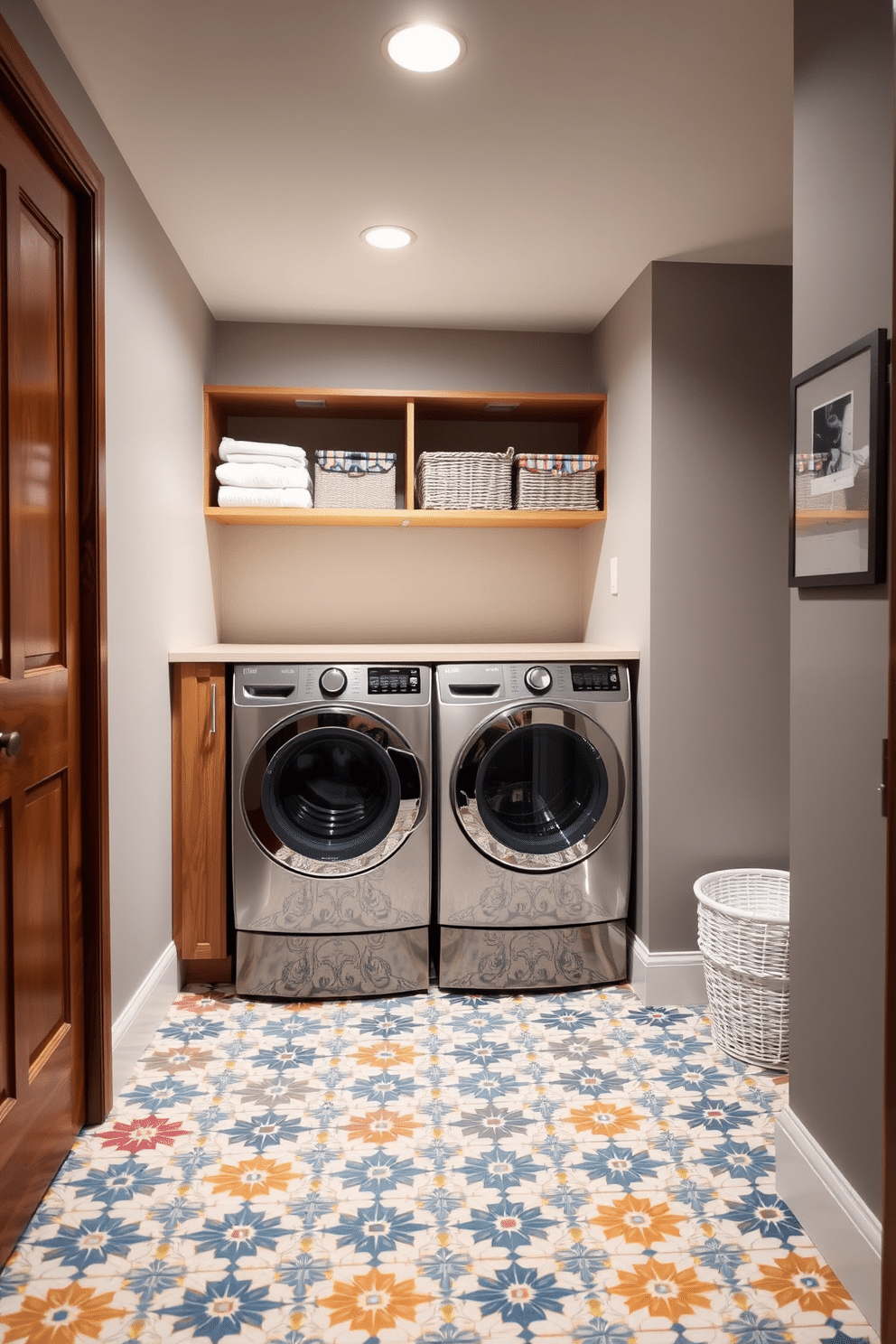 A stylish laundry room in a basement setting features bold patterned floor tiles that add a vibrant character to the space. The walls are painted in a soft gray, creating a modern backdrop for the colorful tiles and enhancing the overall aesthetic. The room includes a sleek, functional washer and dryer set, neatly tucked into cabinetry with a warm wood finish. Above the appliances, open shelves display neatly folded towels and decorative baskets, combining practicality with charm.