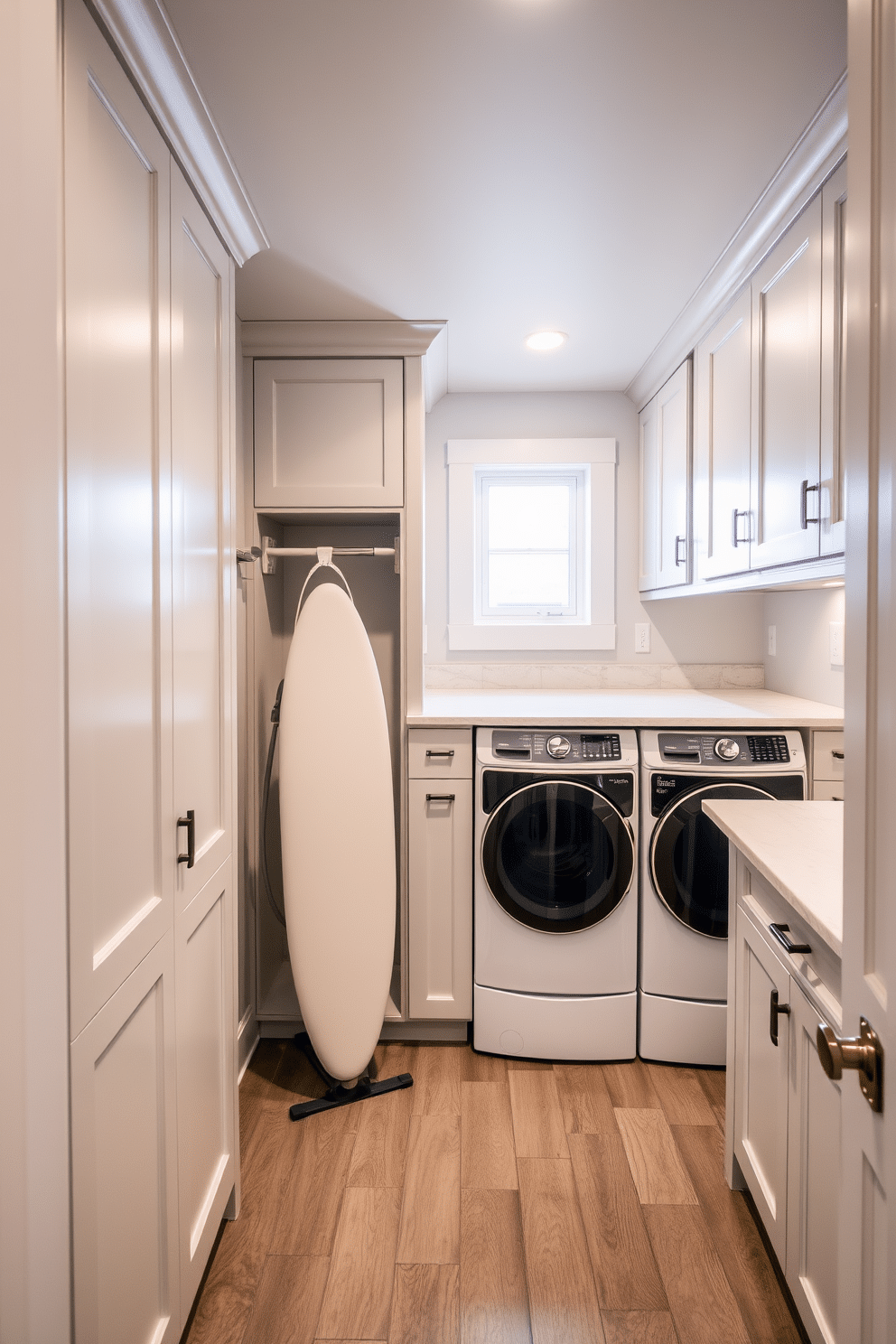 A well-organized laundry room in the basement features a built-in ironing board that folds down seamlessly from a custom cabinetry unit. The space is illuminated by soft, recessed lighting, and the walls are painted in a light gray to create a clean and airy atmosphere. The cabinetry includes ample storage for laundry supplies, with a countertop for folding clothes and a stylish backsplash that adds a touch of elegance. A durable, easy-to-clean floor complements the functionality of the room, while a small window provides natural light, enhancing the overall design.