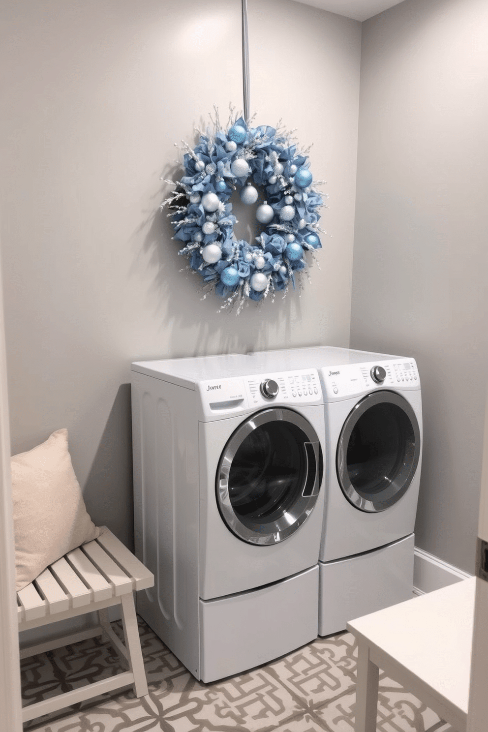 A laundry room adorned with a beautiful blue and silver wreath, elegantly hung above a sleek white washer and dryer. The walls are painted in a soft gray, while the floor features a stylish geometric tile pattern that complements the festive decor. The wreath is embellished with shimmering silver accents and delicate blue ornaments, creating a cheerful focal point. A cozy bench with plush pillows sits against the wall, providing a perfect spot for folding laundry while enjoying the holiday spirit.