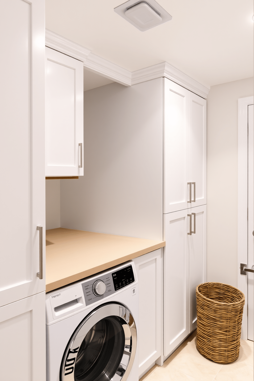 A modern laundry room featuring stackable units for efficient space utilization. The stacked washer and dryer are positioned against a wall, surrounded by sleek cabinetry in a crisp white finish, providing ample storage for laundry essentials. The room is illuminated by recessed lighting, creating a bright and inviting atmosphere. A countertop above the washer and dryer offers a convenient folding space, while a woven basket sits nearby for added organization.