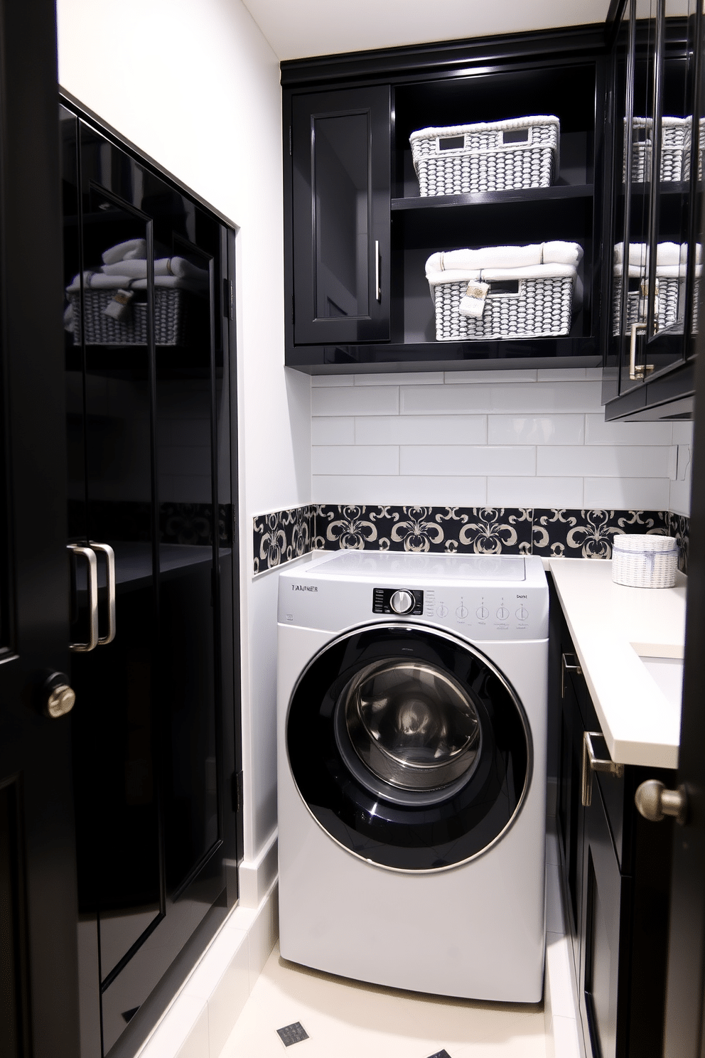 A sophisticated laundry room featuring a top-loading washer in a sleek black and white palette. The room is accented with glossy black cabinetry, contrasting with white countertops that provide ample workspace. The walls are adorned with elegant black and white patterned tiles, creating a stylish backdrop. A decorative shelf above the washer holds neatly folded towels and chic storage baskets, adding both functionality and flair.