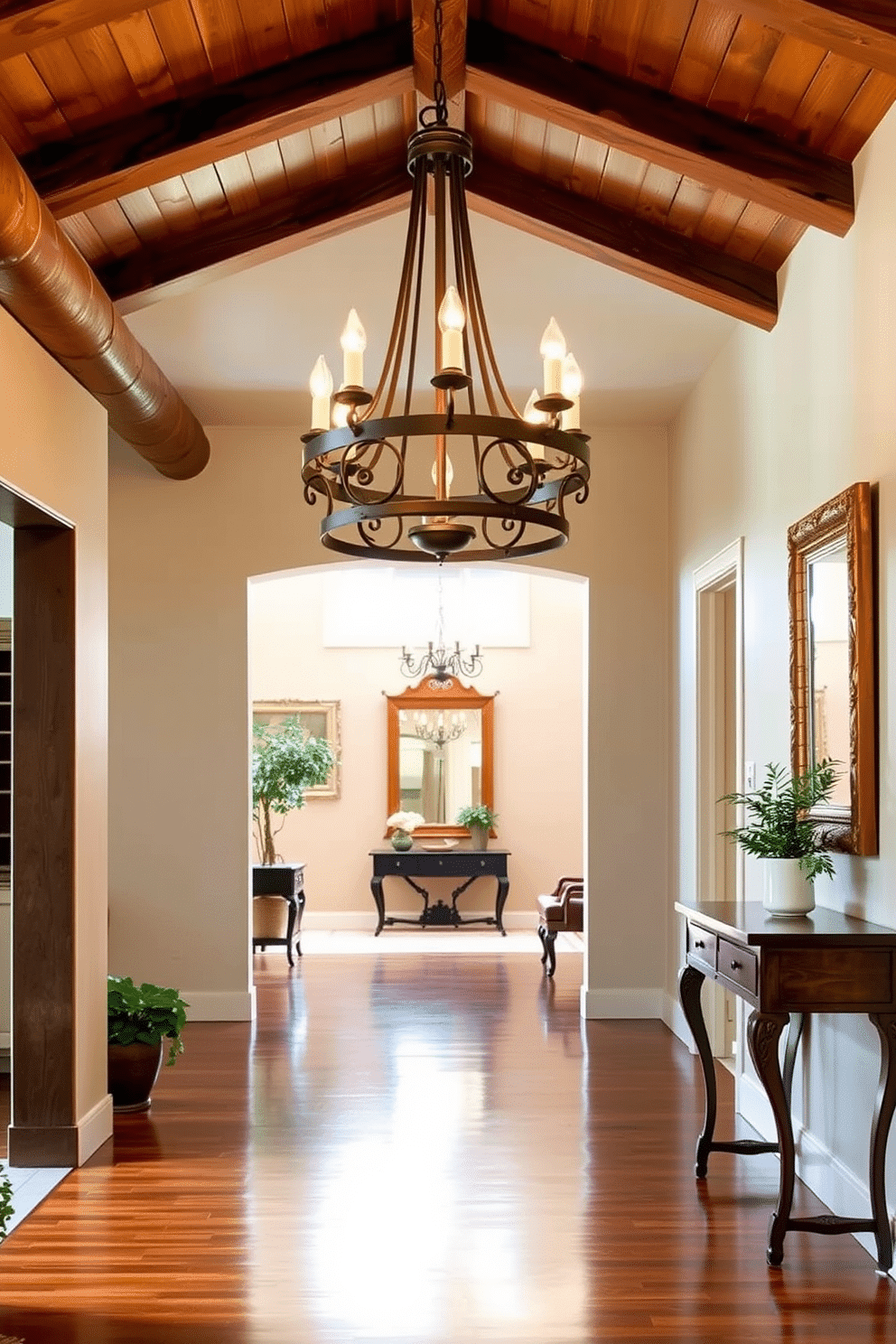 A rustic chandelier hangs from a wooden beam ceiling, casting a warm glow over a cozy living space. The chandelier features wrought iron accents and vintage-style bulbs, enhancing the inviting ambiance. The long foyer is adorned with a polished hardwood floor that leads to an elegantly framed mirror at the far end. Flanking the entrance are potted plants and a console table, creating a welcoming and stylish first impression.