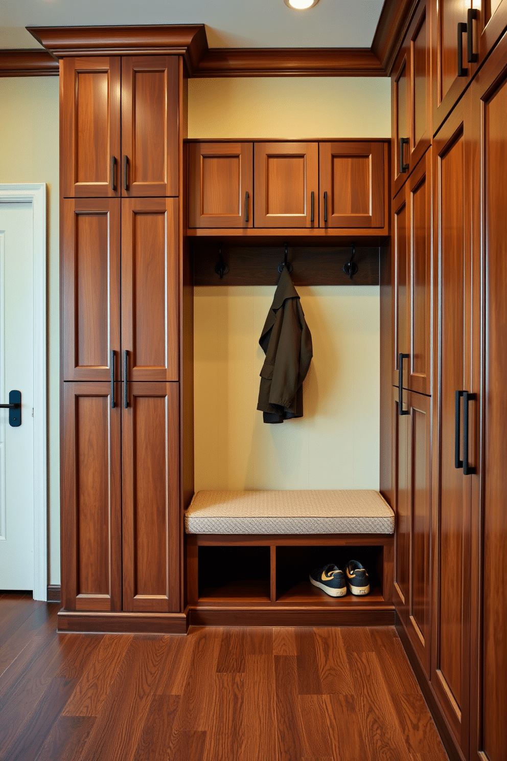 A luxury mudroom features expansive floor-to-ceiling cabinets crafted from rich wood, providing ample storage for shoes, coats, and accessories. The space is accented with a stylish bench upholstered in soft fabric, paired with elegant hooks for hanging outerwear, all set against a backdrop of warm, inviting colors.