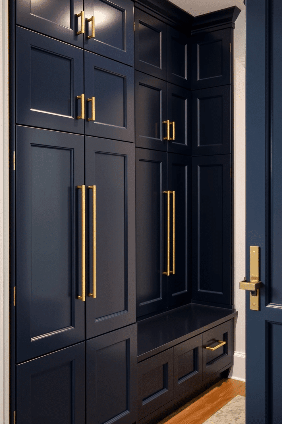 A luxurious mudroom features custom cabinetry with sleek hardware accents, designed for both functionality and style. The cabinetry is finished in a rich navy blue, complemented by brushed gold handles, creating an elegant yet practical space for storage and organization.