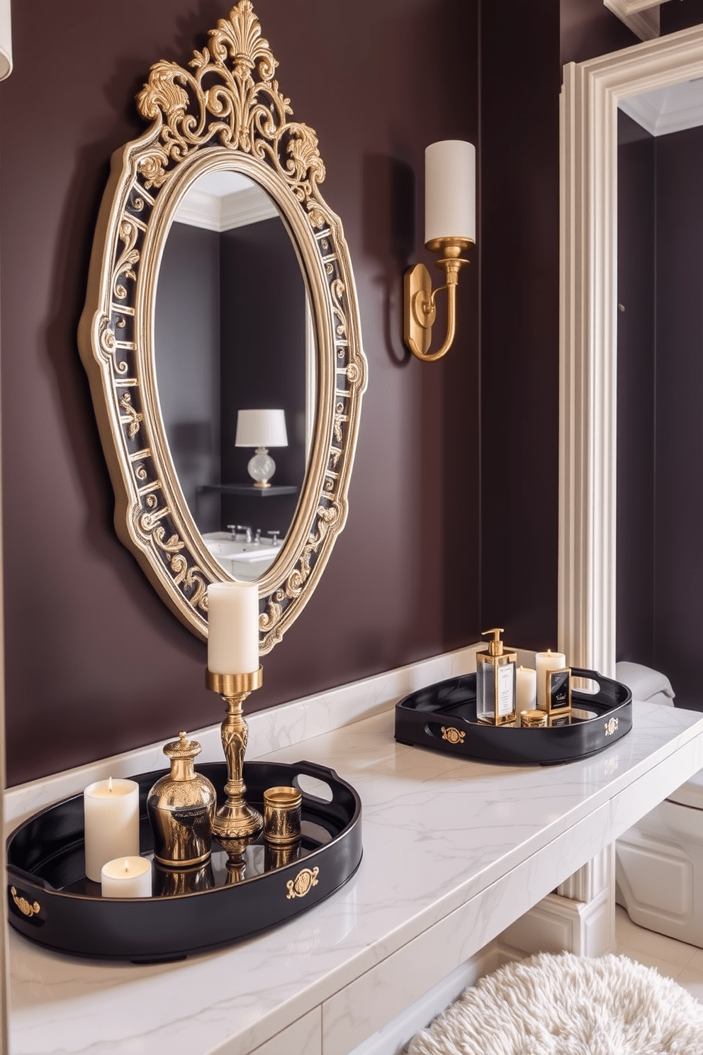 A luxurious powder room featuring decorative trays elegantly arranged on a marble countertop. The trays hold scented candles and exquisite hand soaps, enhancing the sophisticated ambiance of the space. The walls are adorned with a rich, deep color, complemented by gold accents throughout. A stylish mirror with a decorative frame reflects the opulence of the room, while a plush rug adds warmth underfoot.