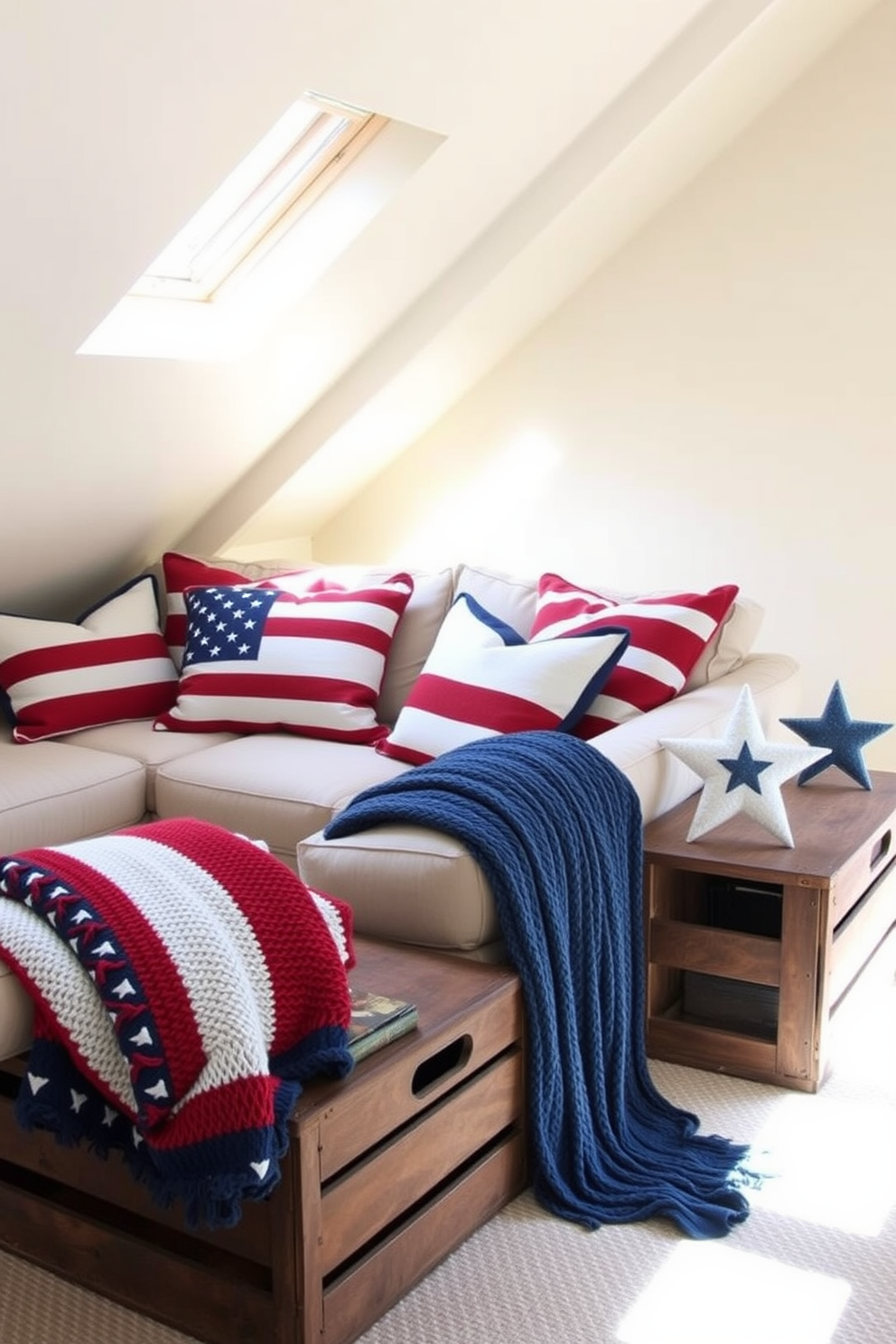 A cozy attic space adorned with patriotic throw pillows and blankets in red, white, and blue hues. The pillows are arranged on a comfortable sectional sofa, while a knitted blanket is draped over the armrest, creating a warm and inviting atmosphere. The walls are painted in a soft cream color, enhancing the natural light that filters through the skylights. Vintage wooden crates are used as side tables, showcasing decorative stars and stripes accents that celebrate Memorial Day.