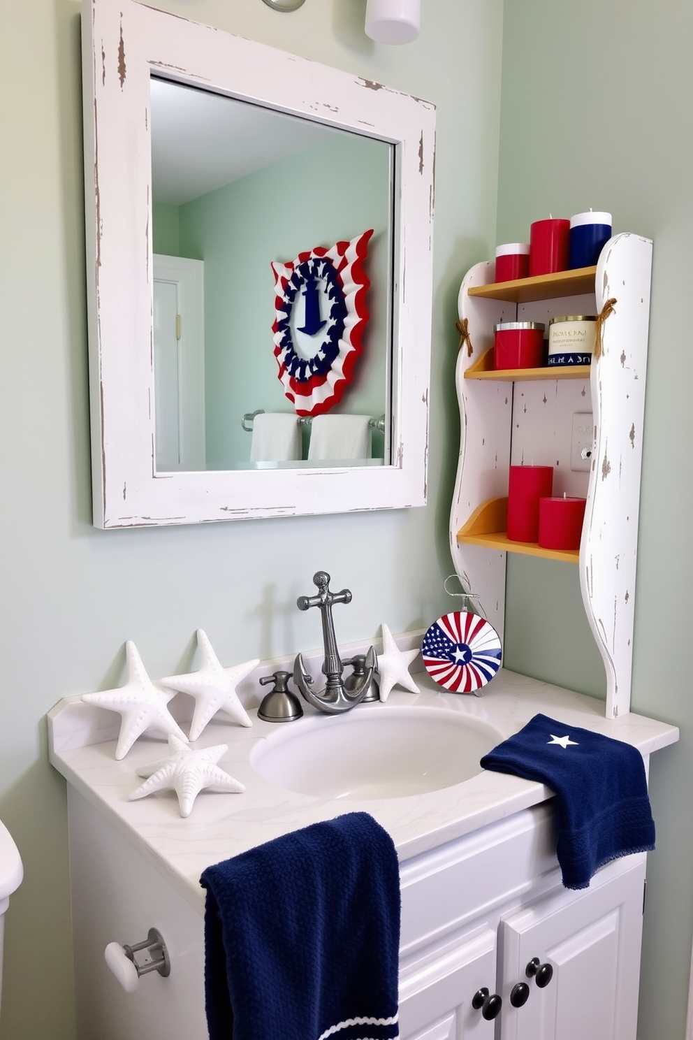 A coastal-themed bathroom decorated for Memorial Day. Ceramic starfish and anchor decor are arranged on a white marble countertop, with a navy blue towel draped over a silver towel rack. The walls are painted in a soft seafoam green, and a large mirror with a distressed white frame hangs above the sink. Red, white, and blue candles are placed on a wooden shelf, adding a festive touch.