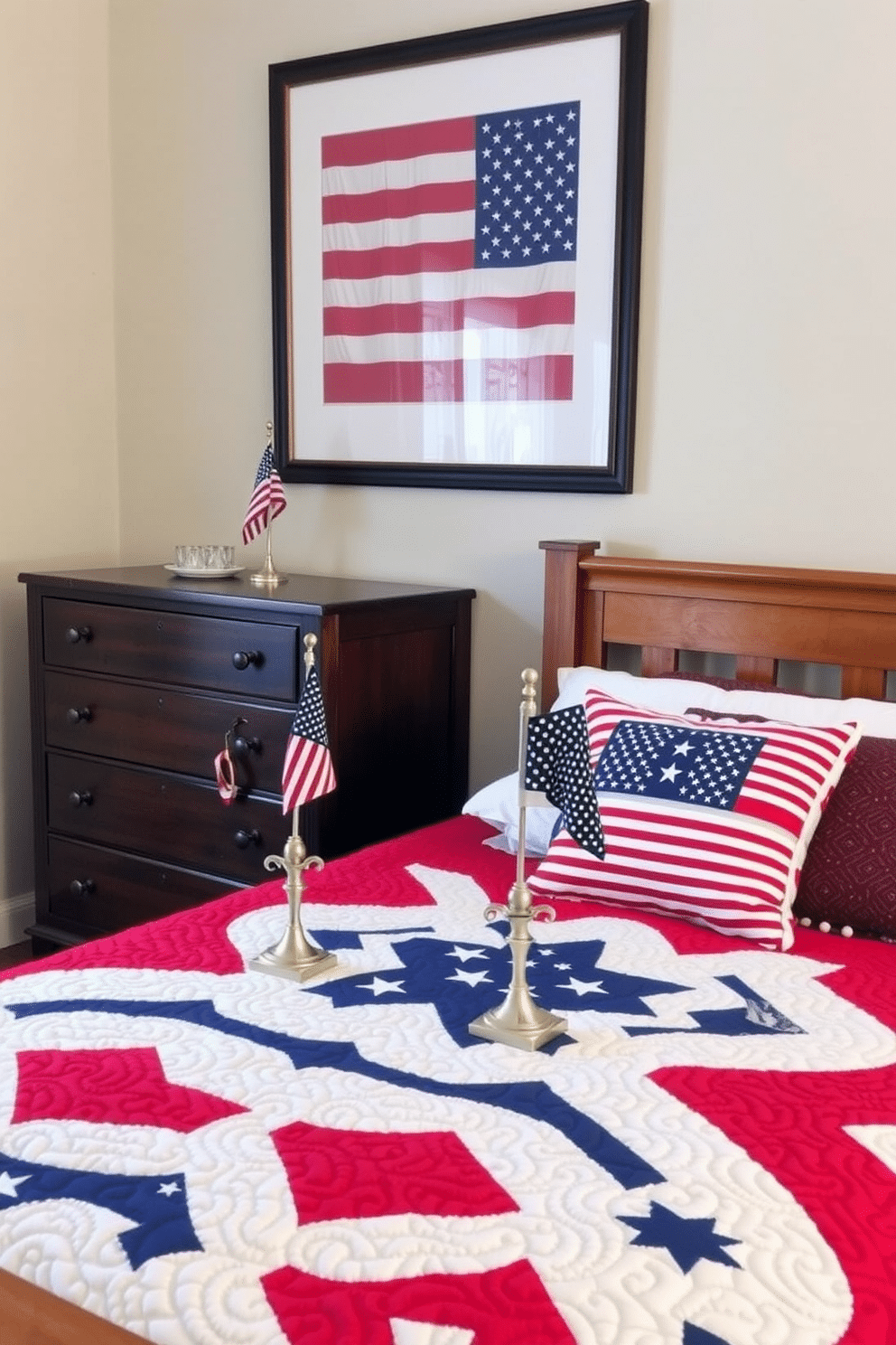 A cozy bedroom decorated for Memorial Day. A wooden dresser stands against the wall, featuring two small tabletop flags in elegant holders, adding a patriotic touch. The bed is adorned with a red, white, and blue quilt, complemented by star-spangled pillows. Above the headboard, a framed American flag art piece hangs, creating a focal point for the room.