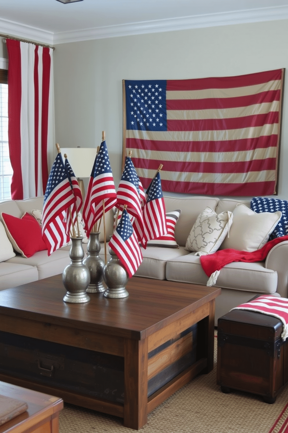 A cozy living room decorated for Memorial Day. Vintage American flags are arranged in decorative vases placed on a rustic wooden coffee table. The room features a classic red, white, and blue color scheme, with throw pillows and blankets in patriotic patterns adorning a comfortable sofa. A large framed flag hangs on the wall, and a vintage trunk serves as additional seating.