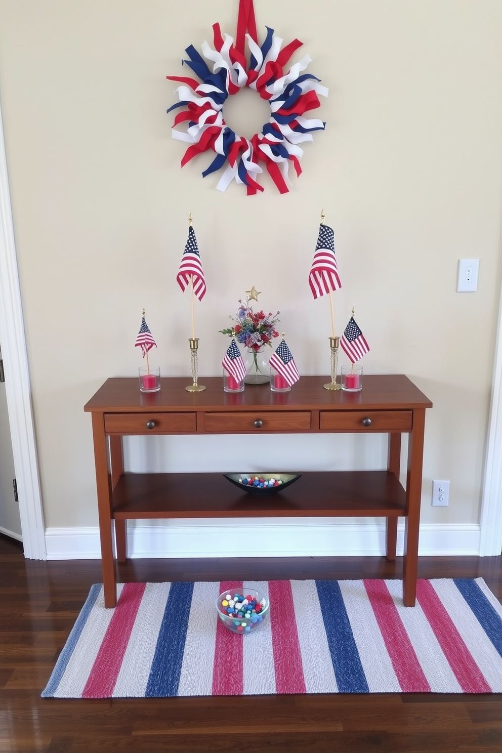 A festive entryway decorated for Memorial Day. A wooden console table features miniature American flag arrangements in small glass vases, accompanied by red, white, and blue candles. Above the console, a patriotic wreath made of red, white, and blue ribbons hangs on the wall. The floor is adorned with a striped runner rug in matching colors, and a small bowl of star-shaped candies sits on the table, welcoming guests with a touch of holiday spirit.