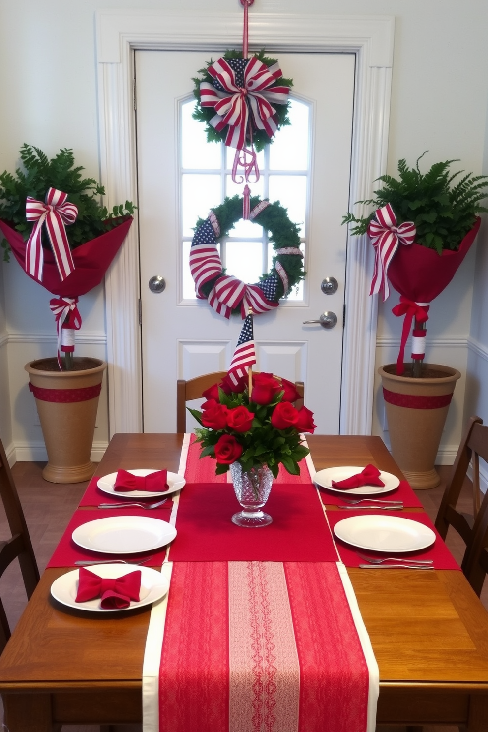 A festive dining area featuring a red and white striped tablecloth draped over a rectangular wooden table. The table is set with white porcelain plates, red napkins, and silver cutlery, complemented by a centerpiece of fresh red roses in a crystal vase. A welcoming Memorial Day entryway adorned with patriotic decorations. The door is flanked by two large potted plants wrapped in red, white, and blue ribbons, while a festive wreath made of small American flags hangs in the center of the door.