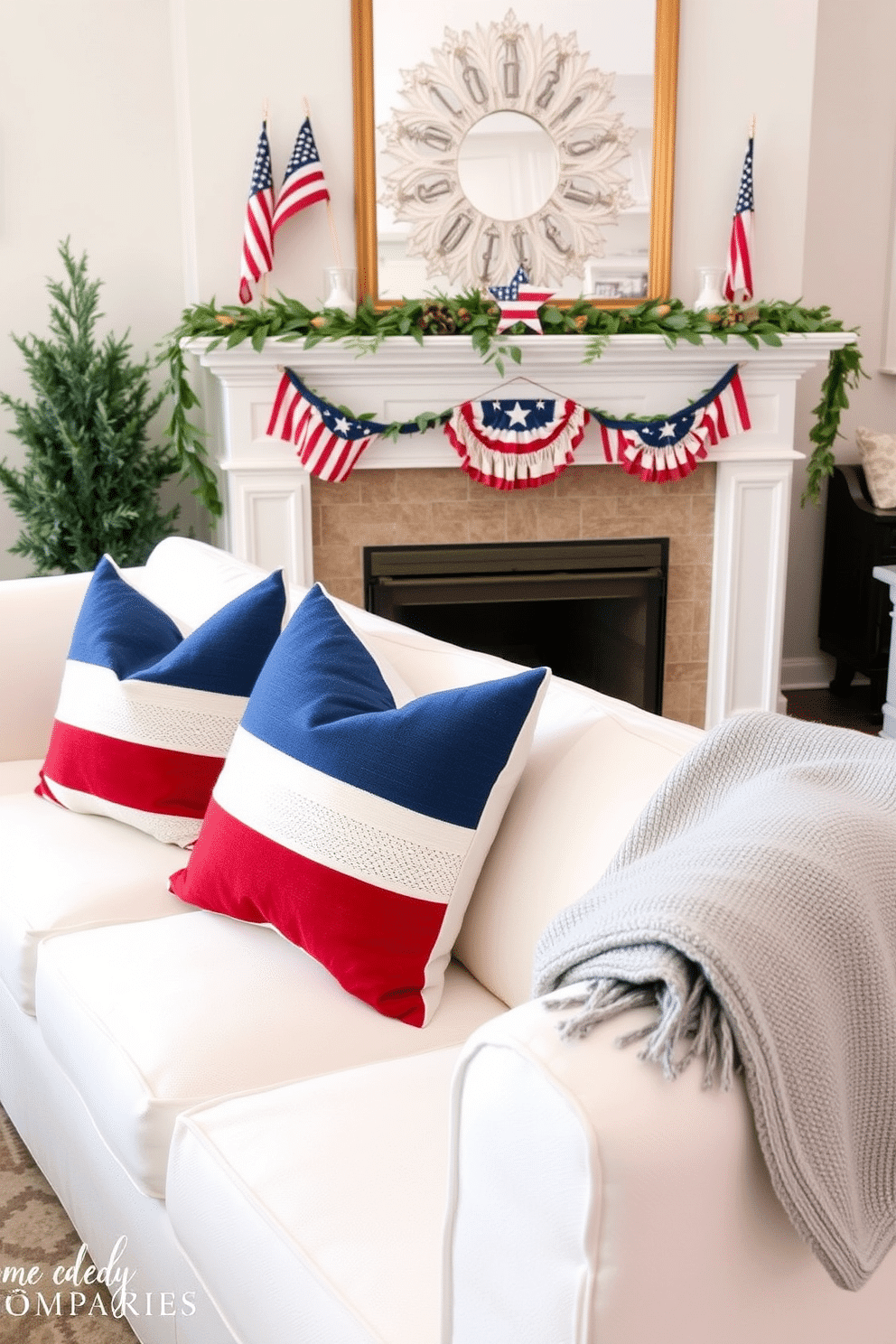 Create a cozy living room setting featuring seasonal throw pillows in red white and blue flag colors. The pillows are artfully arranged on a plush white sofa, complemented by a soft gray throw blanket draped over the arm. In the background, a beautifully decorated fireplace serves as the focal point. The mantel is adorned with patriotic decorations including small flags and seasonal greenery, creating a festive atmosphere for Memorial Day.