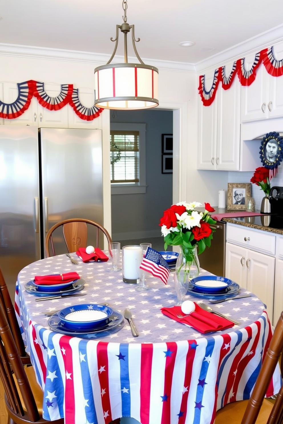 A Memorial Day-themed kitchen with a stars and stripes tablecloth adorning the dining table. The table is set with blue and white plates, red napkins, and silver cutlery, creating a festive and patriotic atmosphere. Above the table, a pendant light with a red, white, and blue lampshade adds a touch of holiday spirit. The kitchen walls are painted a soft white, with red, white, and blue bunting hanging from the cabinets, and a vase of fresh flowers in patriotic colors sits on the countertop.