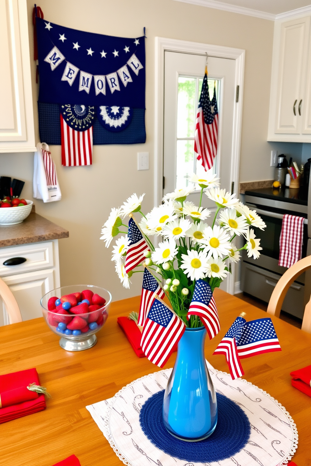 A cozy kitchen decorated for Memorial Day. A patriotic cookie jar sits on the counter, featuring red, white, and blue stars and stripes, next to a bowl of fresh strawberries. The kitchen walls are adorned with festive banners and American flags, while red, white, and blue dish towels hang from the oven handle. On the dining table, a centerpiece of white daisies in a blue vase is surrounded by small American flags and red, white, and blue napkins.