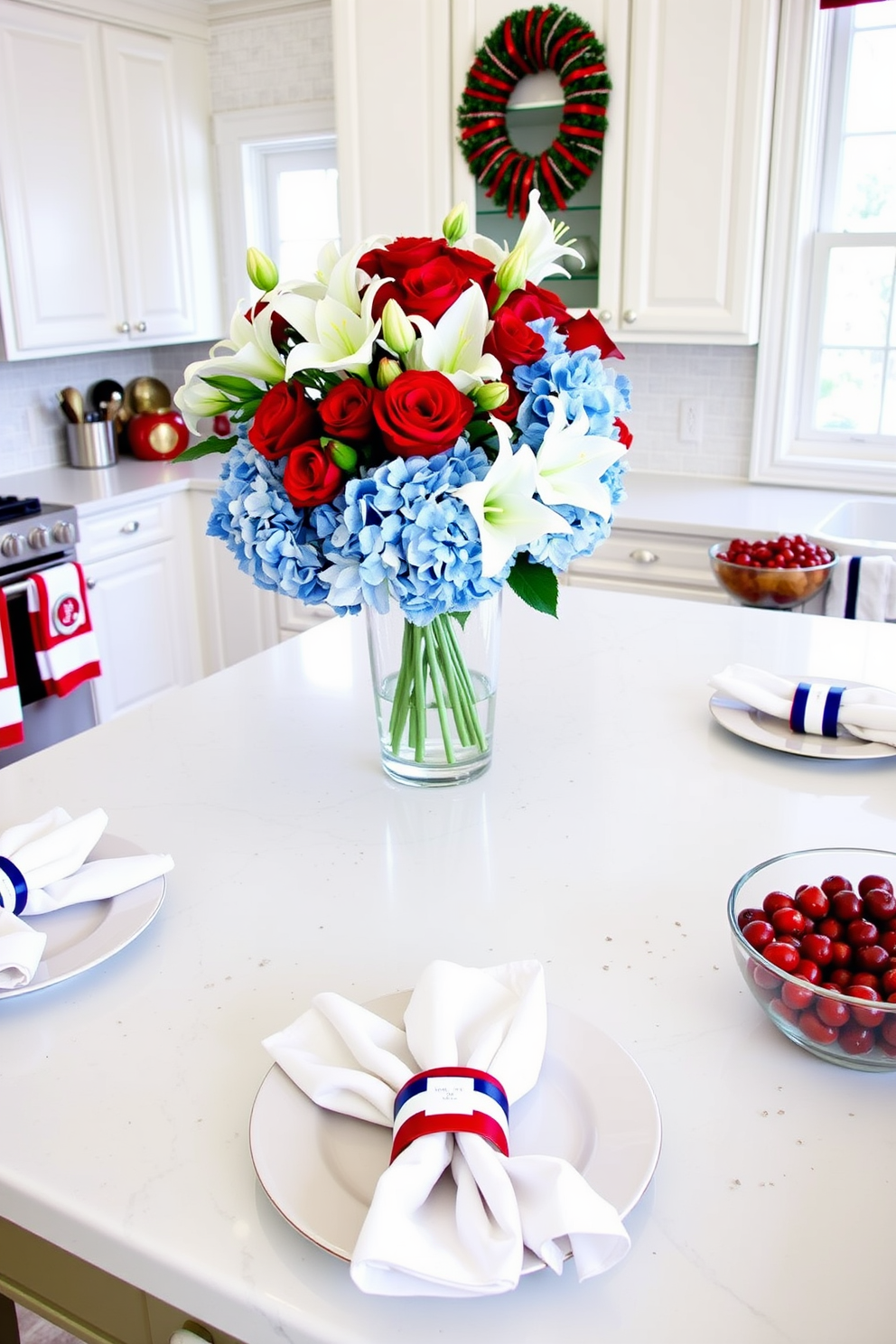 A bright and festive kitchen setup. Red, white, and blue napkin rings are placed around crisp white napkins, which are neatly arranged on each plate. The kitchen island is adorned with a patriotic centerpiece featuring a mix of red roses, white lilies, and blue hydrangeas in a clear glass vase. The countertops are decorated with coordinating red, white, and blue dish towels and a bowl of fresh berries to enhance the holiday spirit.