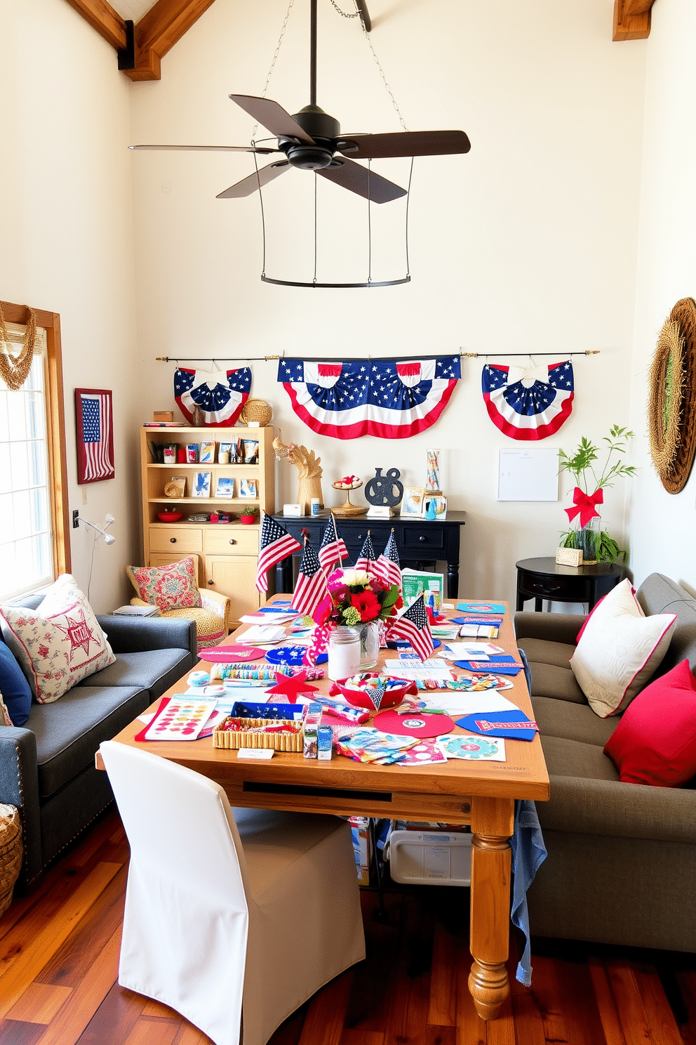 A cozy craft corner for kids filled with patriotic project materials. The space features a large table covered in red white and blue craft supplies including stickers ribbons and paper. The loft is decorated for Memorial Day with a mix of rustic and modern elements. Comfortable seating is arranged around a centerpiece of vibrant flowers and small American flags.