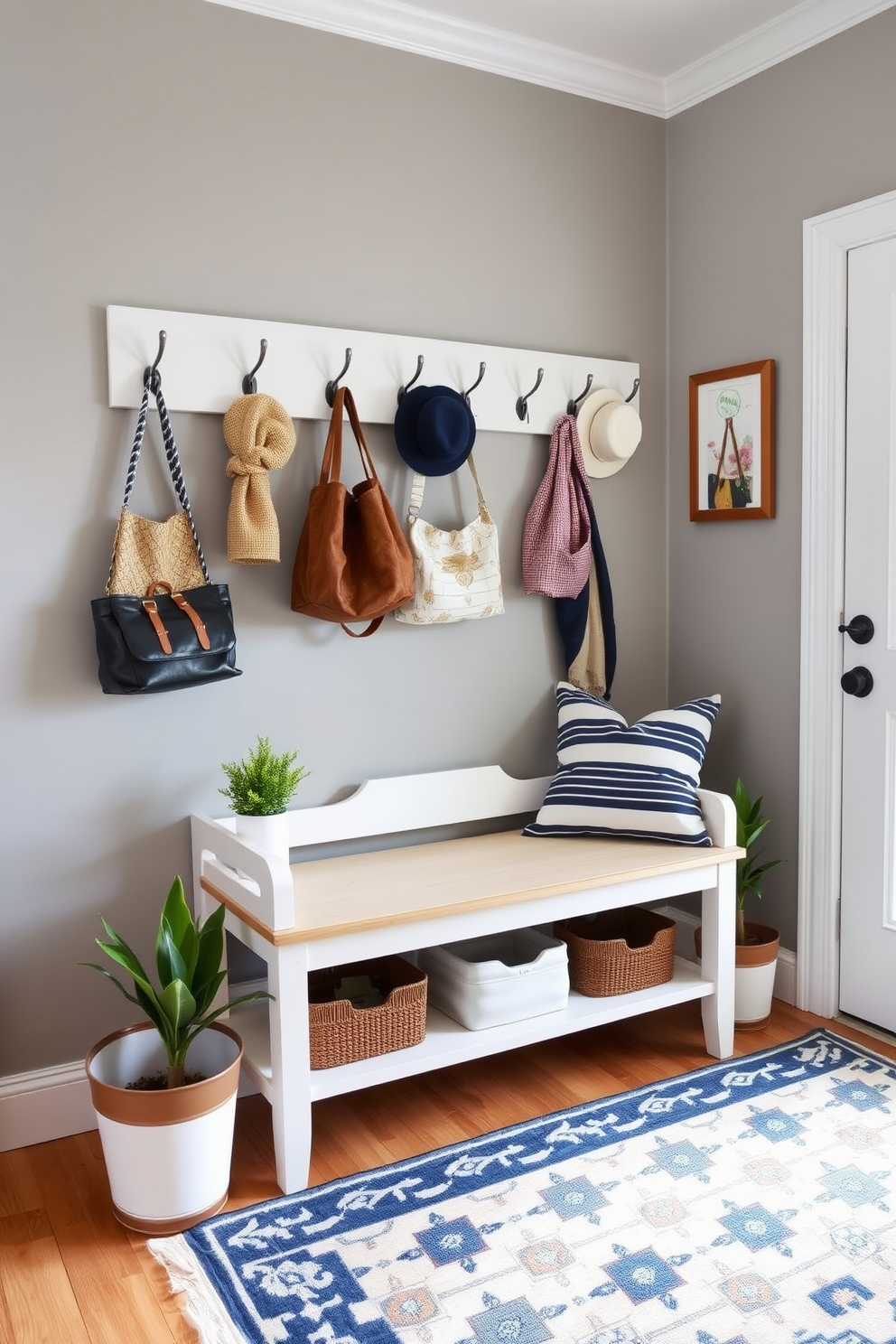 A stylish mudroom featuring wall-mounted hooks for hats and bags. The walls are painted in a soft gray, and the floor is covered with a durable patterned rug that adds warmth and character. Decorative elements include a vintage bench with storage underneath and potted plants on either side. A cheerful color palette of navy blue and white accents brings a fresh, inviting feel to the space.