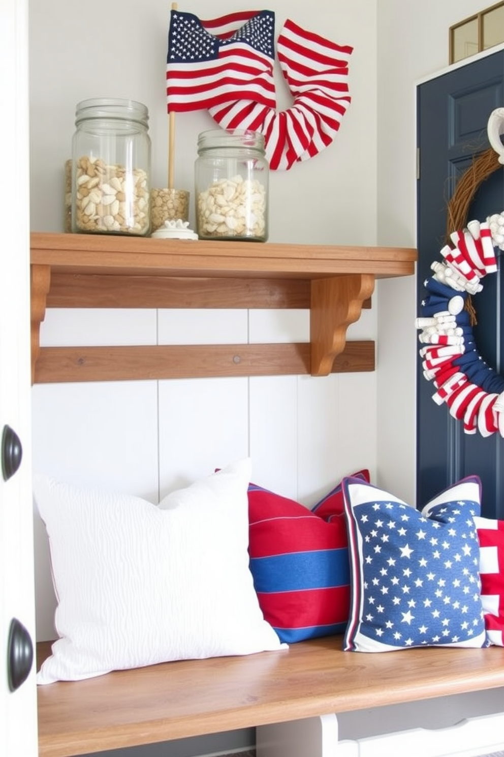 Decorative jars filled with sand and shells sit elegantly on a wooden shelf. The jars are arranged in varying heights, showcasing a mix of textures and colors that evoke a coastal vibe. For Memorial Day, the mudroom is adorned with patriotic accents. A red, white, and blue color scheme is complemented by seasonal decor such as stars and stripes pillows on a bench and a wreath made of mini flags on the door.