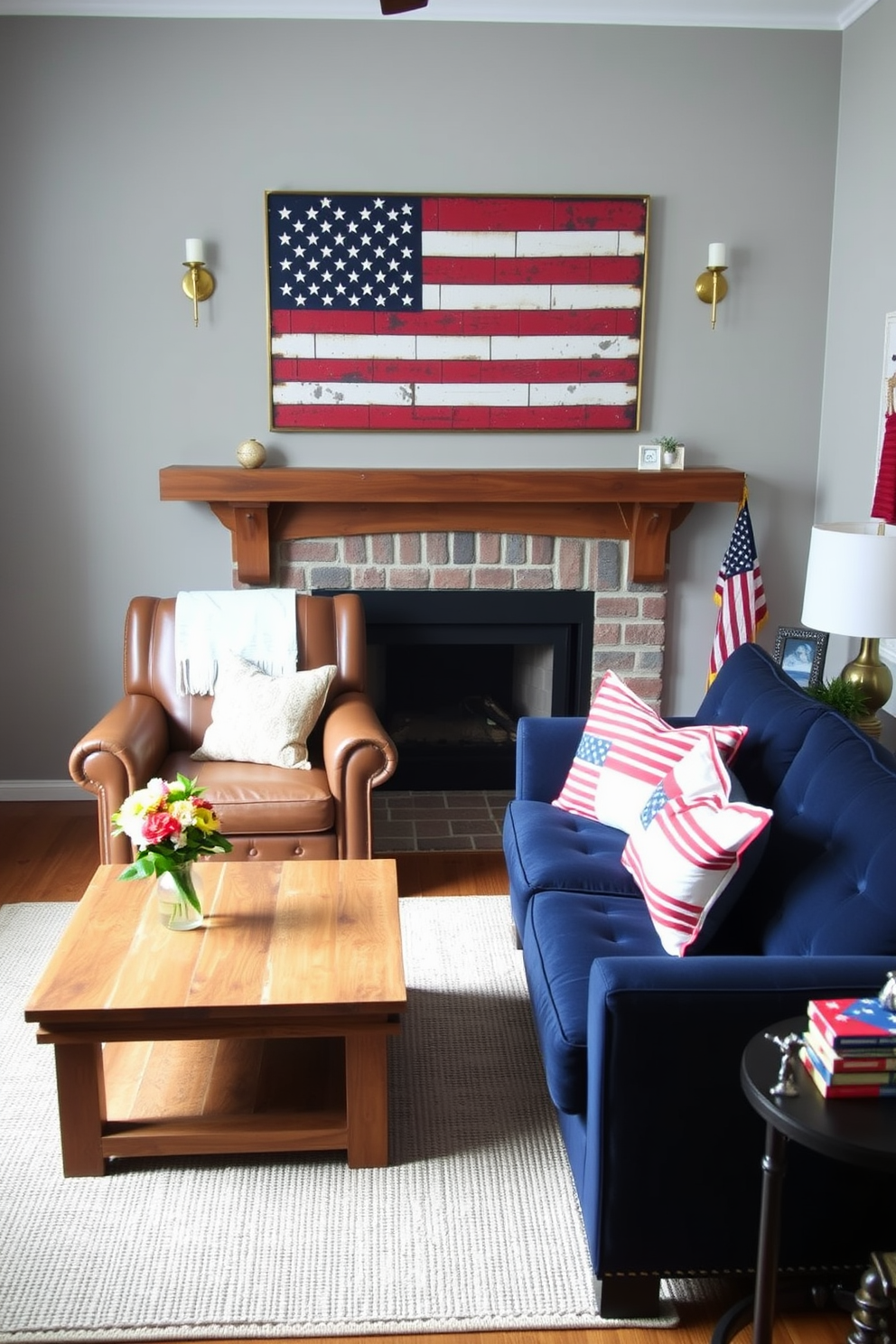 A cozy small living room decorated for Memorial Day. A vintage American flag wall art piece hangs prominently above a rustic wooden mantle, flanked by two brass sconces. Below, a distressed leather armchair and a navy blue loveseat are arranged around a reclaimed wood coffee table. Patriotic-themed throw pillows in red, white, and blue adorn the seating, while a woven rug in muted tones ties the space together. A small side table holds a vase with fresh flowers and a few patriotic decorations, creating a warm and inviting atmosphere perfect for the holiday.