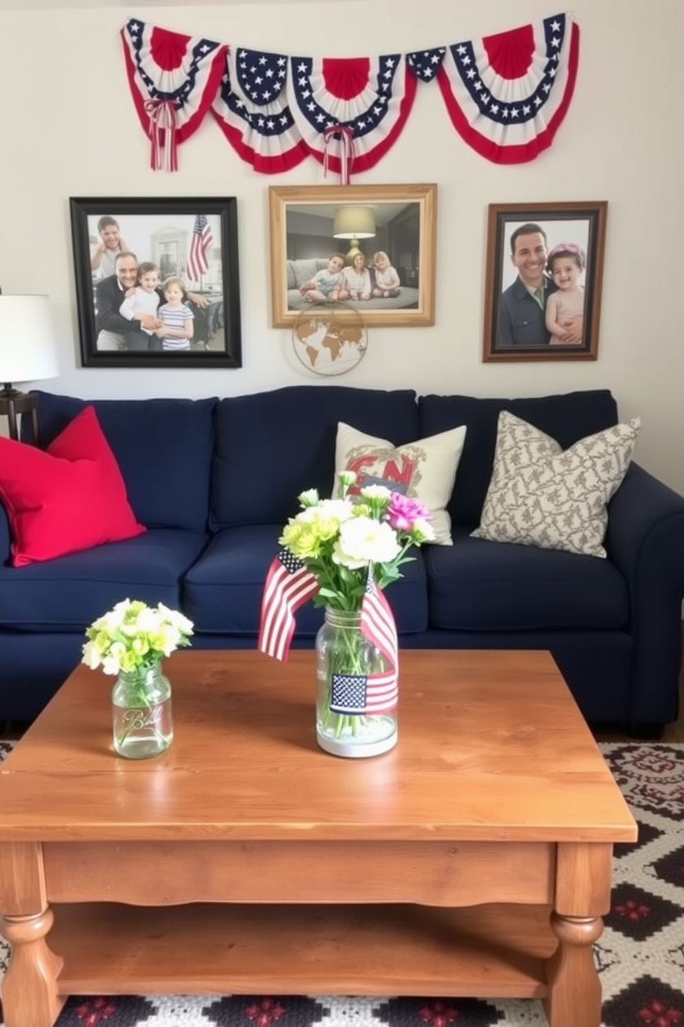 A cozy small living room decorated for Memorial Day. The space features a navy blue sofa adorned with red and white throw pillows, and a rustic wooden coffee table at its center. On the coffee table, there are DIY painted mason jars with American flags, filled with fresh flowers. The walls are decorated with patriotic banners and framed photographs of family gatherings, creating a warm and inviting atmosphere.