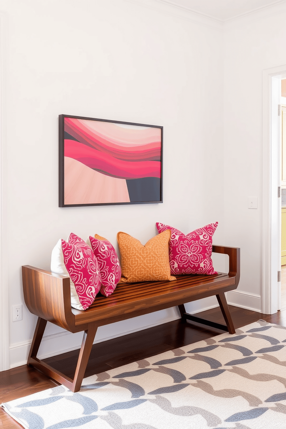 A welcoming foyer featuring a sleek wooden bench adorned with vibrant, patterned cushions. The walls are painted in a soft, neutral tone, complemented by a geometric area rug that adds warmth to the space.