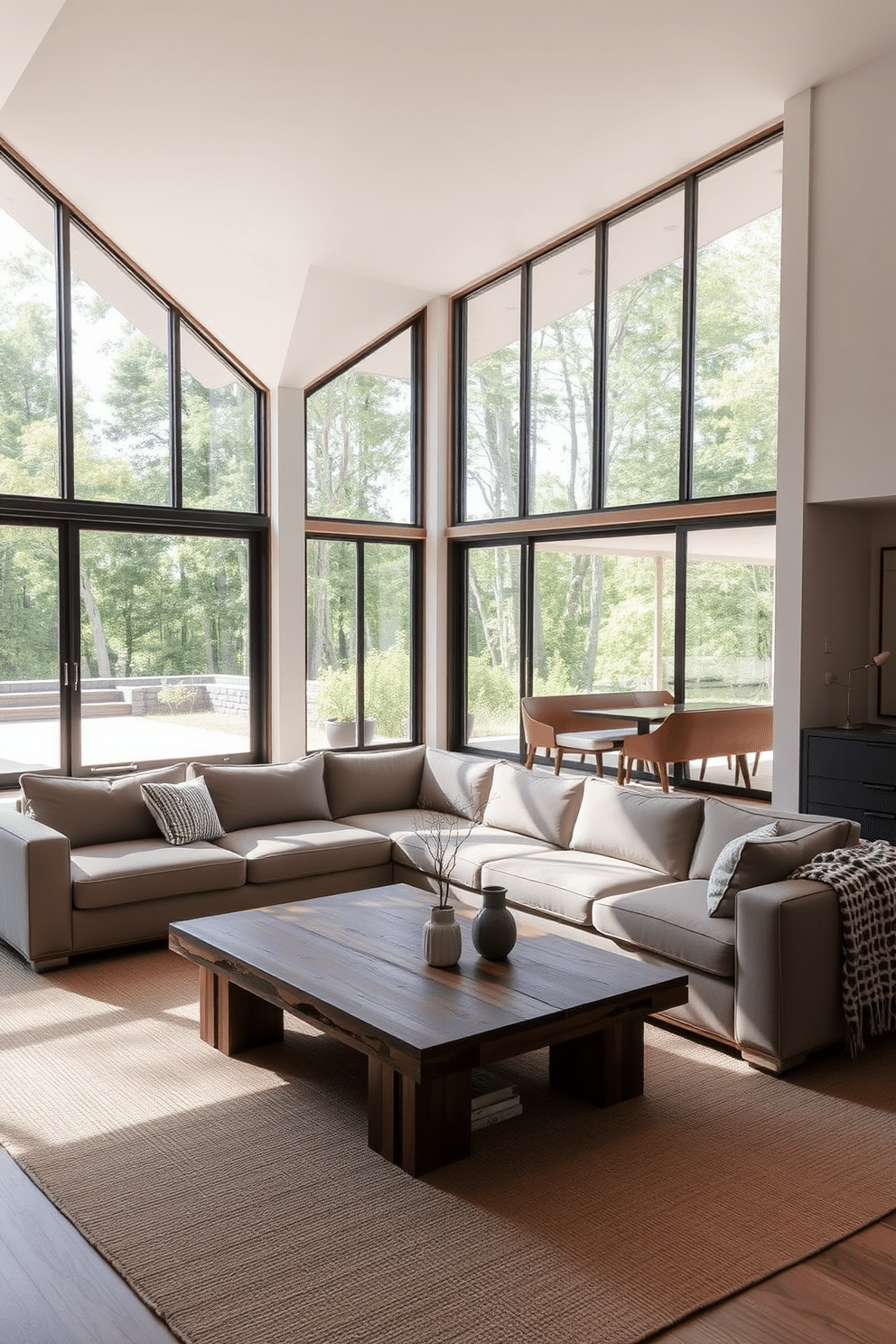 A spacious family room bathed in natural light, featuring large floor-to-ceiling windows that invite the outdoors in. The room is designed with a minimalist aesthetic, showcasing a neutral color palette, sleek furniture, and open spaces that promote relaxation and comfort. A low-profile sectional sofa in soft gray is complemented by a simple coffee table made of reclaimed wood. A few carefully selected decorative elements, such as a single potted plant and a textured throw blanket, add warmth without cluttering the space.