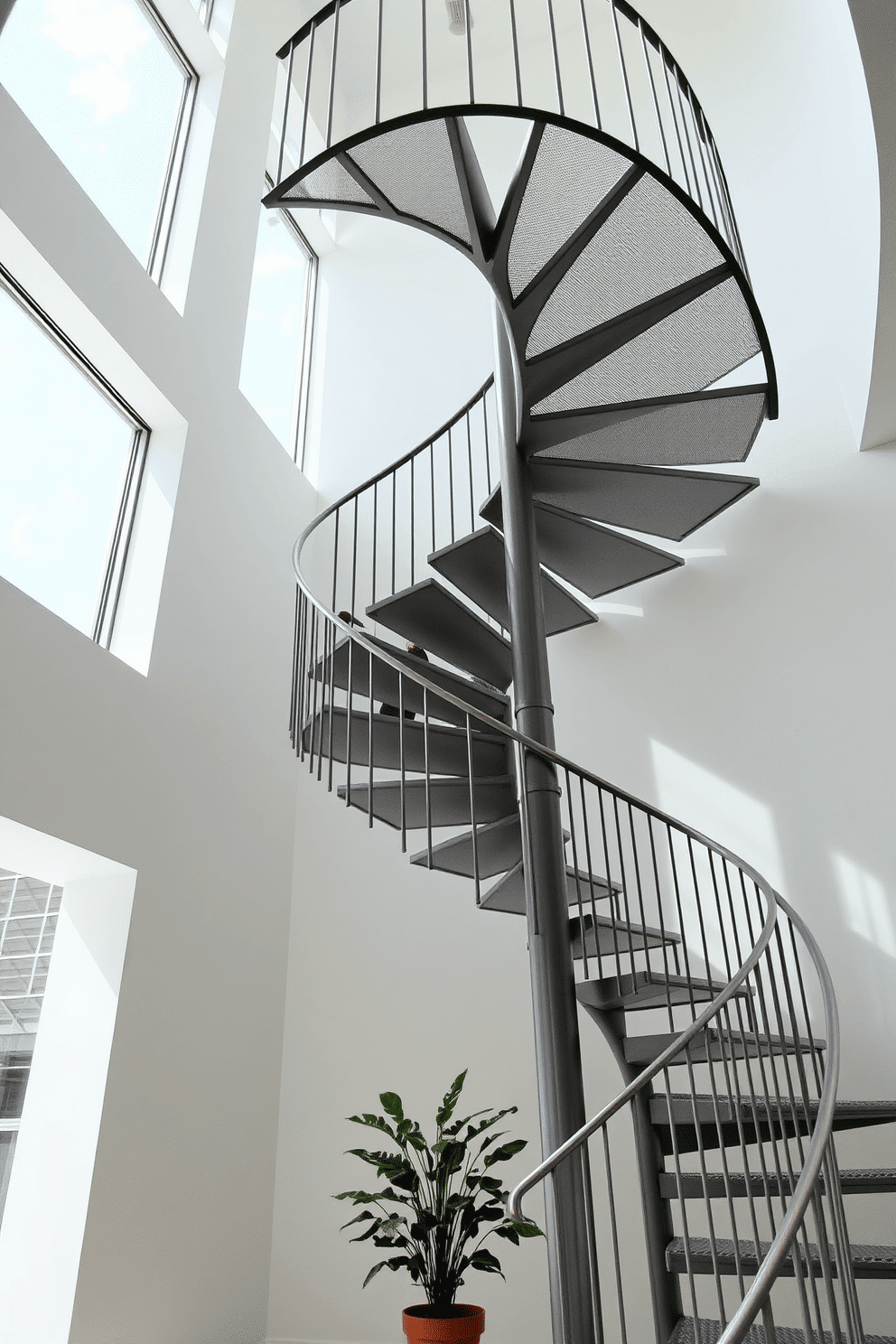 A striking metal spiral staircase with open treads elegantly winds upward, showcasing a sleek, modern design. The staircase is surrounded by a bright, airy space, with large windows allowing natural light to flood in, highlighting the clean lines and minimalist aesthetic. The railings feature a simple yet sophisticated geometric pattern, seamlessly integrating with the overall decor. Below the staircase, a small potted plant adds a touch of greenery, enhancing the minimalist ambiance of the interior.