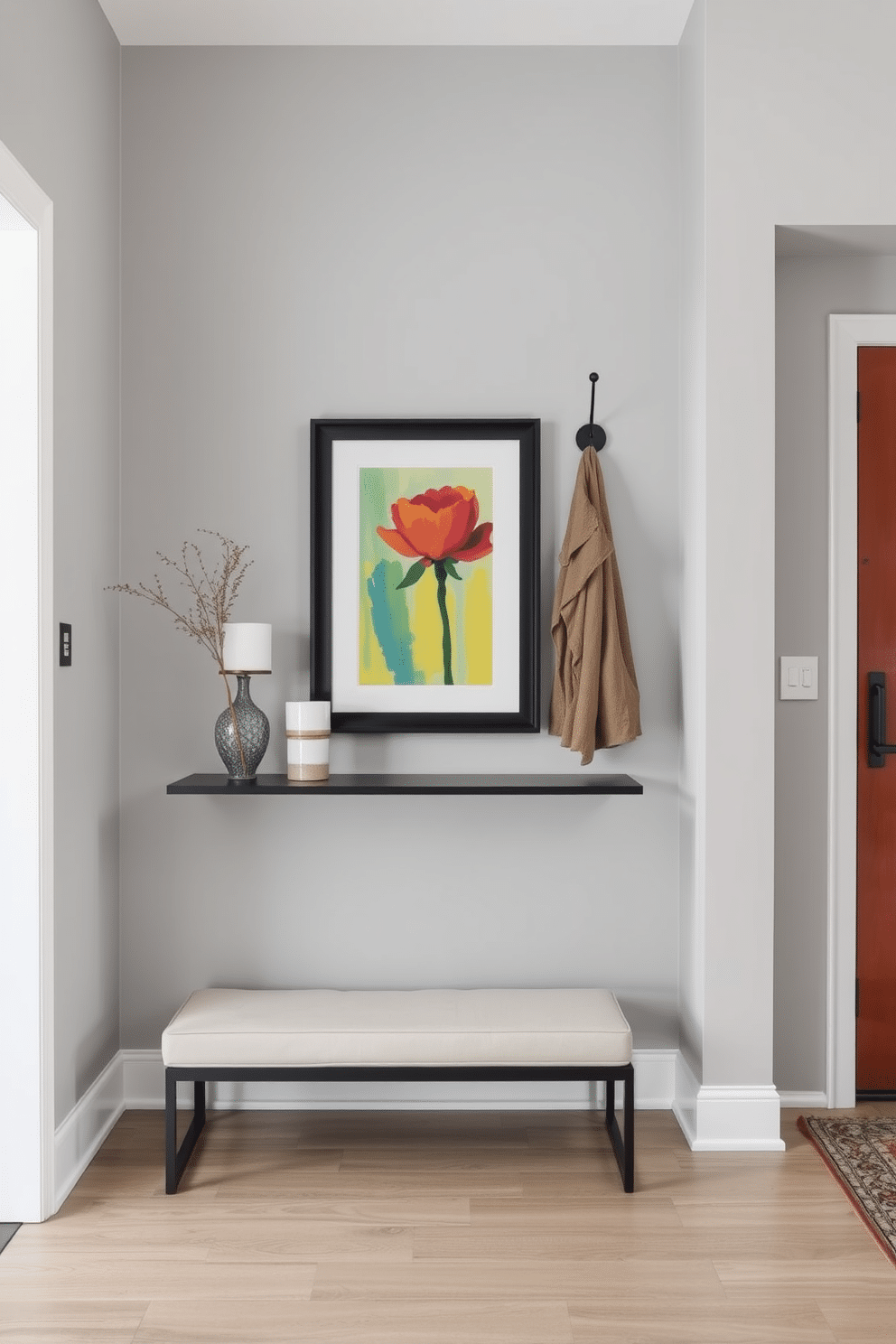 A modern entryway featuring personalized wall art that reflects the homeowner's unique style. The space is adorned with a sleek console table, complemented by a vibrant painting and a few carefully chosen decorative items. The walls are painted in a soft gray, creating a welcoming atmosphere. A minimalist bench sits nearby, with a stylish coat rack mounted above, enhancing both functionality and aesthetic appeal.