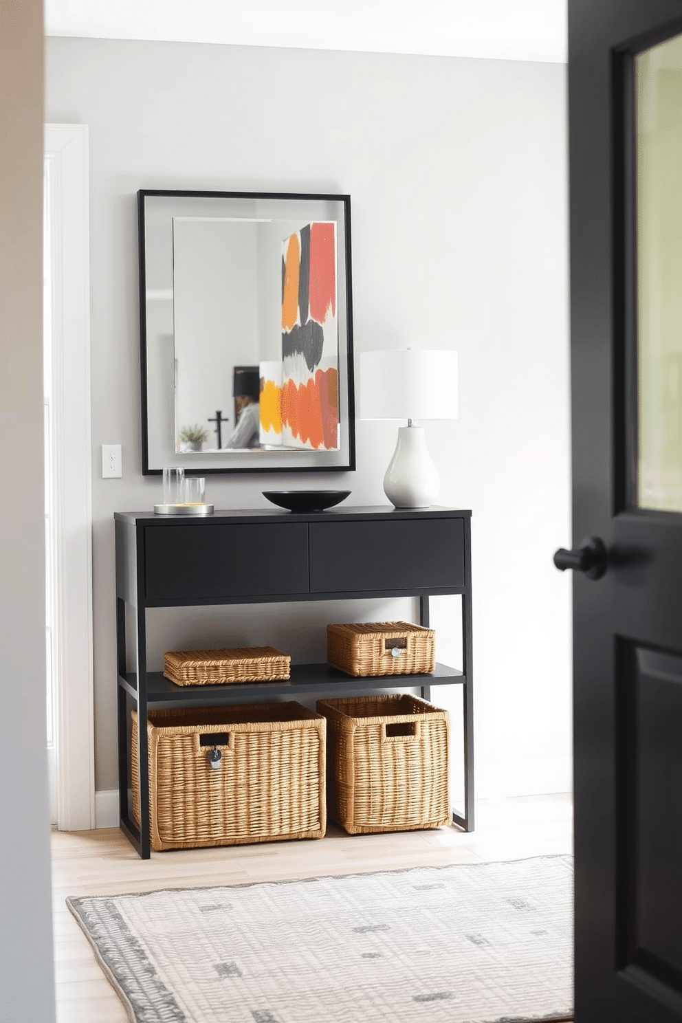 A modern entryway features a sleek console table with a minimalist design, adorned with a stylish lamp and a decorative bowl for keys. The walls are painted in a soft gray, complemented by a vibrant abstract artwork that adds a pop of color. On the floor, a textured area rug defines the space, while stylish woven baskets are neatly arranged beneath the console for organized storage. A large mirror with a thin black frame hangs above the table, reflecting the natural light coming from a nearby window.