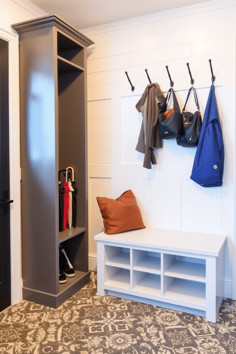 A modern mudroom features vertical storage solutions designed for umbrellas and bags, maximizing space efficiency while maintaining aesthetic appeal. The walls are adorned with light-colored shiplap, and a built-in bench with cubbies provides a functional yet stylish entry point. To the left, a tall, sleek cabinet offers ample storage for umbrellas, while hooks are mounted above for easy access to bags and coats. The floor is finished with durable, patterned tiles that complement the overall design, ensuring both practicality and visual interest.