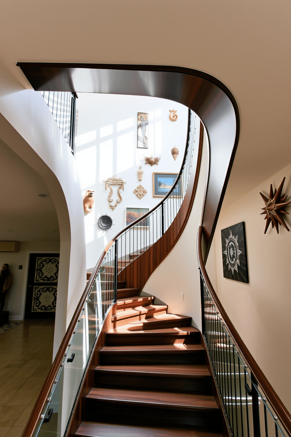 As you ascend the asymmetrical staircase, the elegant curves and sharp angles create a striking visual impact. The railing features a mix of glass and metal, allowing natural light to filter through while enhancing the artistic flair of the design. The staircase is adorned with a rich, dark wood finish that contrasts beautifully with the light-colored walls. A series of unique artwork pieces line the walls, further accentuating the modern aesthetic and inviting a sense of creativity into the space.