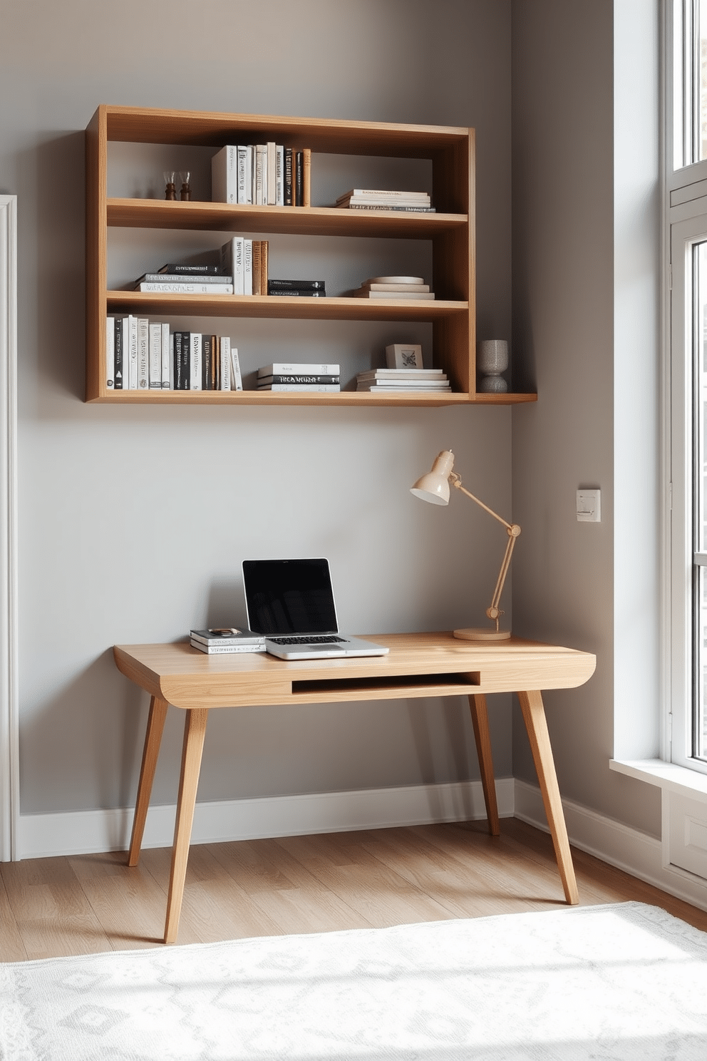 A sleek minimalist desk is positioned against a light gray wall, featuring clean lines and a natural wood finish. Above the desk, open shelving displays a curated selection of books and decorative items, enhancing the room's airy feel. The floor is adorned with a soft, neutral-toned area rug that adds warmth to the space. Large windows allow natural light to flood the room, complemented by a simple yet stylish desk lamp for focused work.