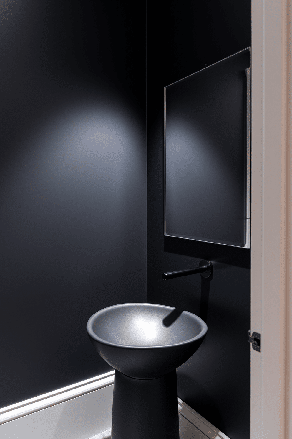 A moody powder room features a sculptural sink in a matte black finish, elegantly positioned against a backdrop of deep charcoal walls. Soft, ambient lighting highlights the unique shape of the sink, while a sleek, minimalist mirror reflects the sophisticated atmosphere of the space.