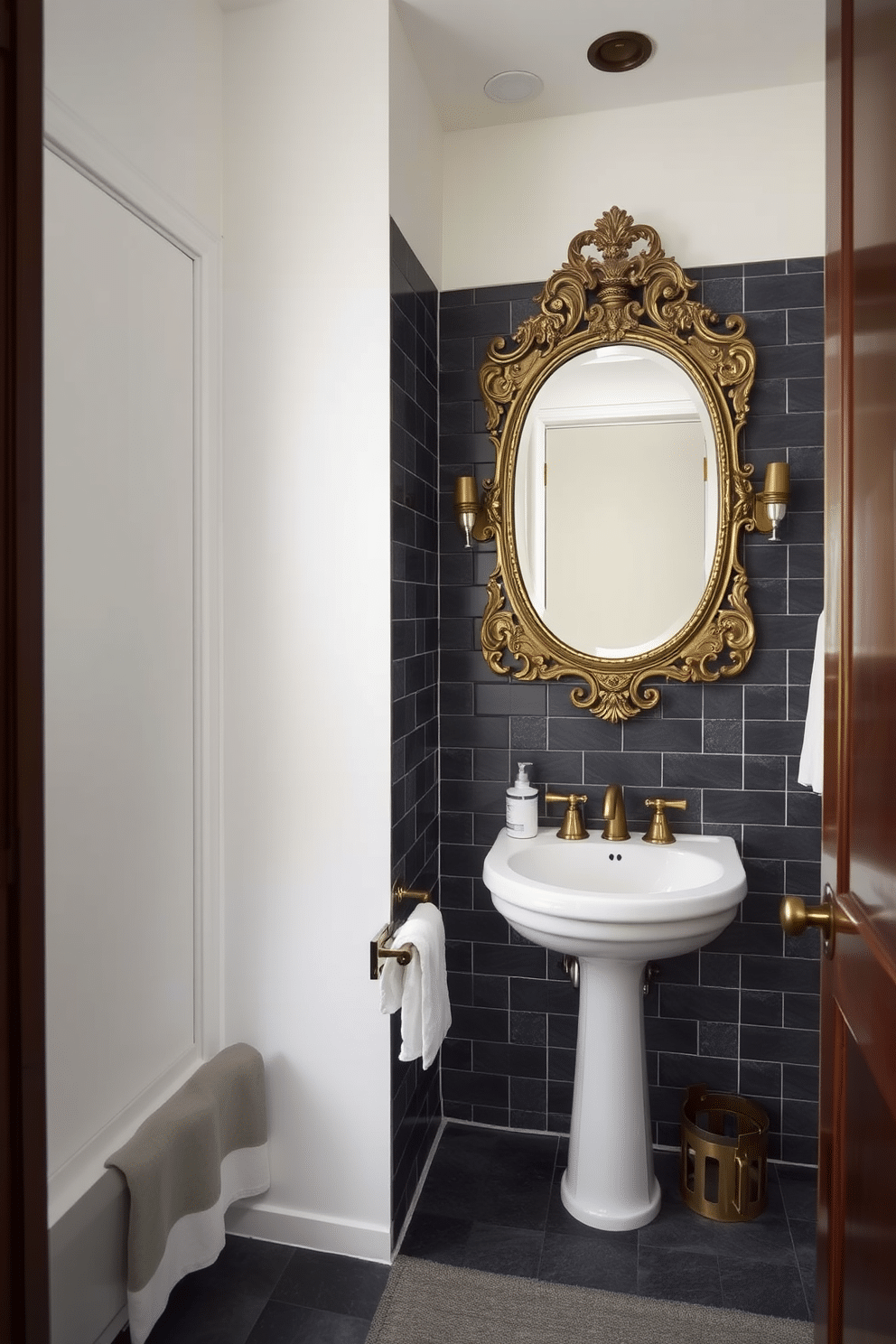 A moody powder room features charcoal gray tiles that create a dramatic and sophisticated atmosphere. Vintage fixtures, including a polished brass faucet and an ornate mirror, add a touch of timeless elegance to the space.